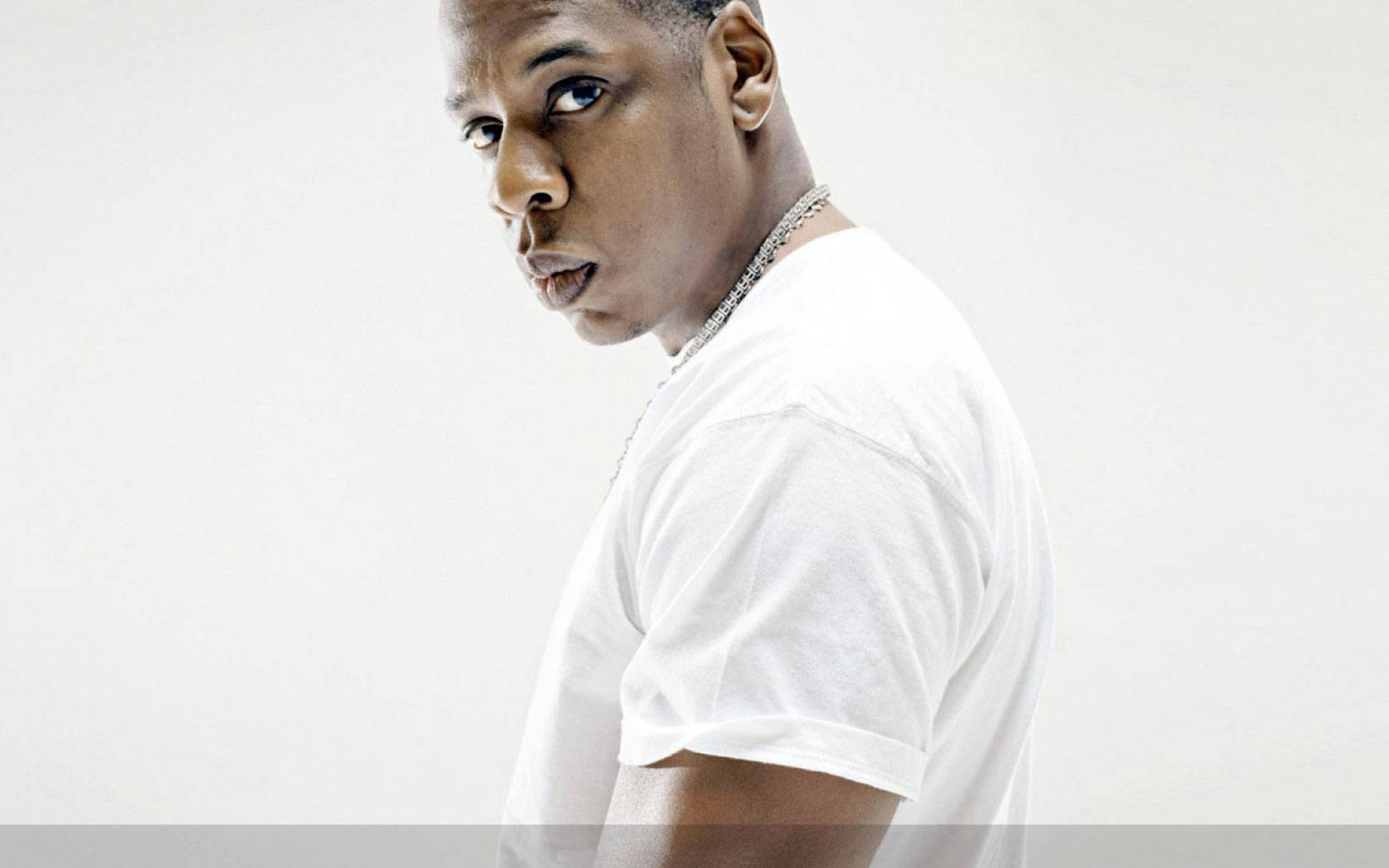 Jay-z 桌布 壁紙 — 一個穿著白色T恤的男人轉頭直視相機，背景是純白色。
