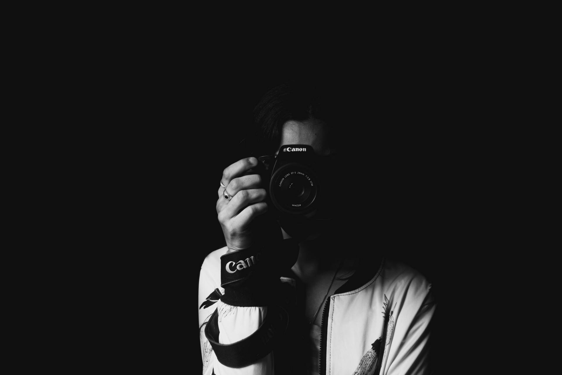在黑暗環境中手持相機的人。 — 攝影師 GIF 壁紙