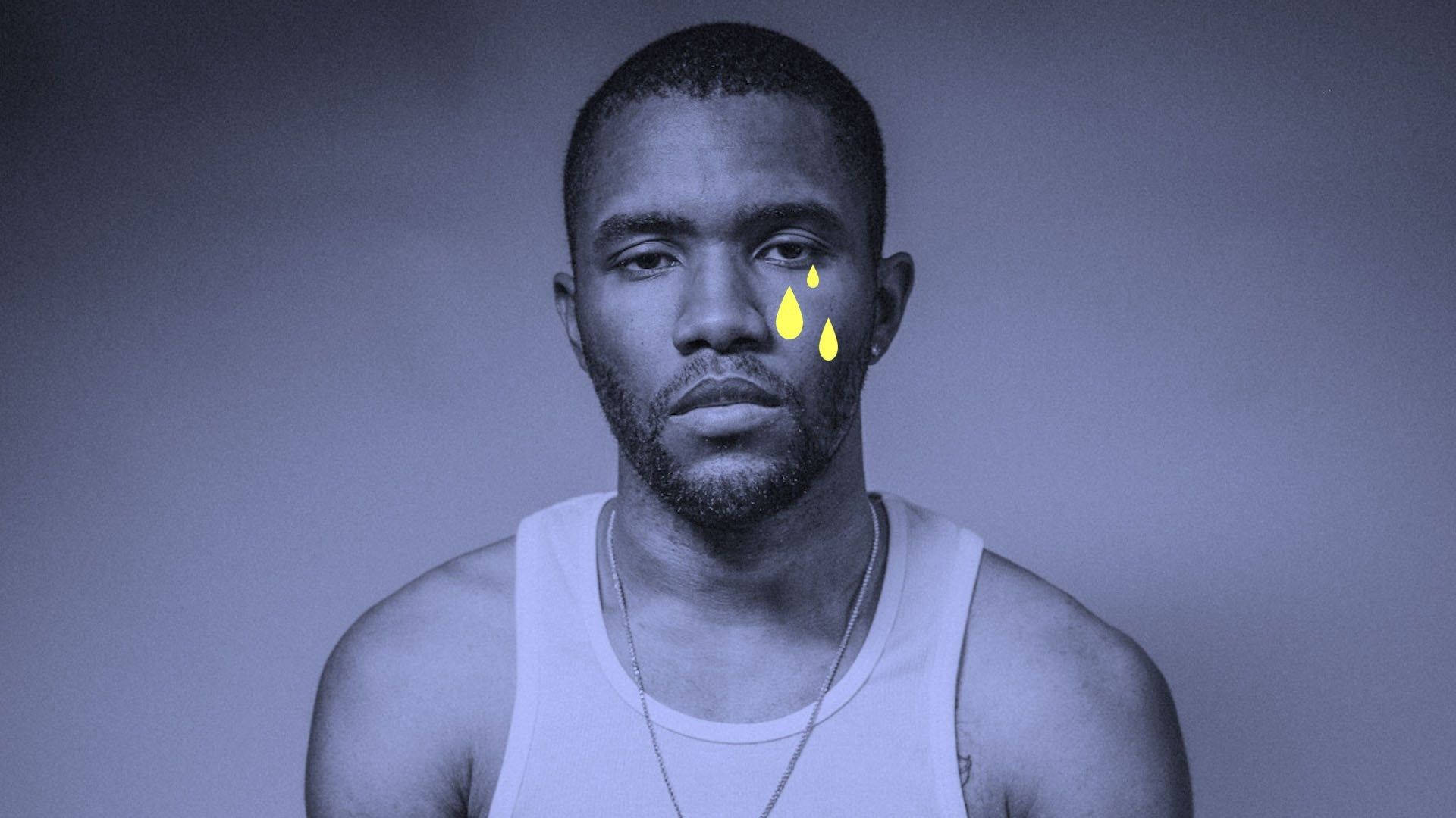 Frank Ocean 桌布 壁紙 — 一個穿著白色背心的男人嚴肅地凝視著，發光的黃色淚珠順著他的臉頰流下，背景是柔和的藍灰色。