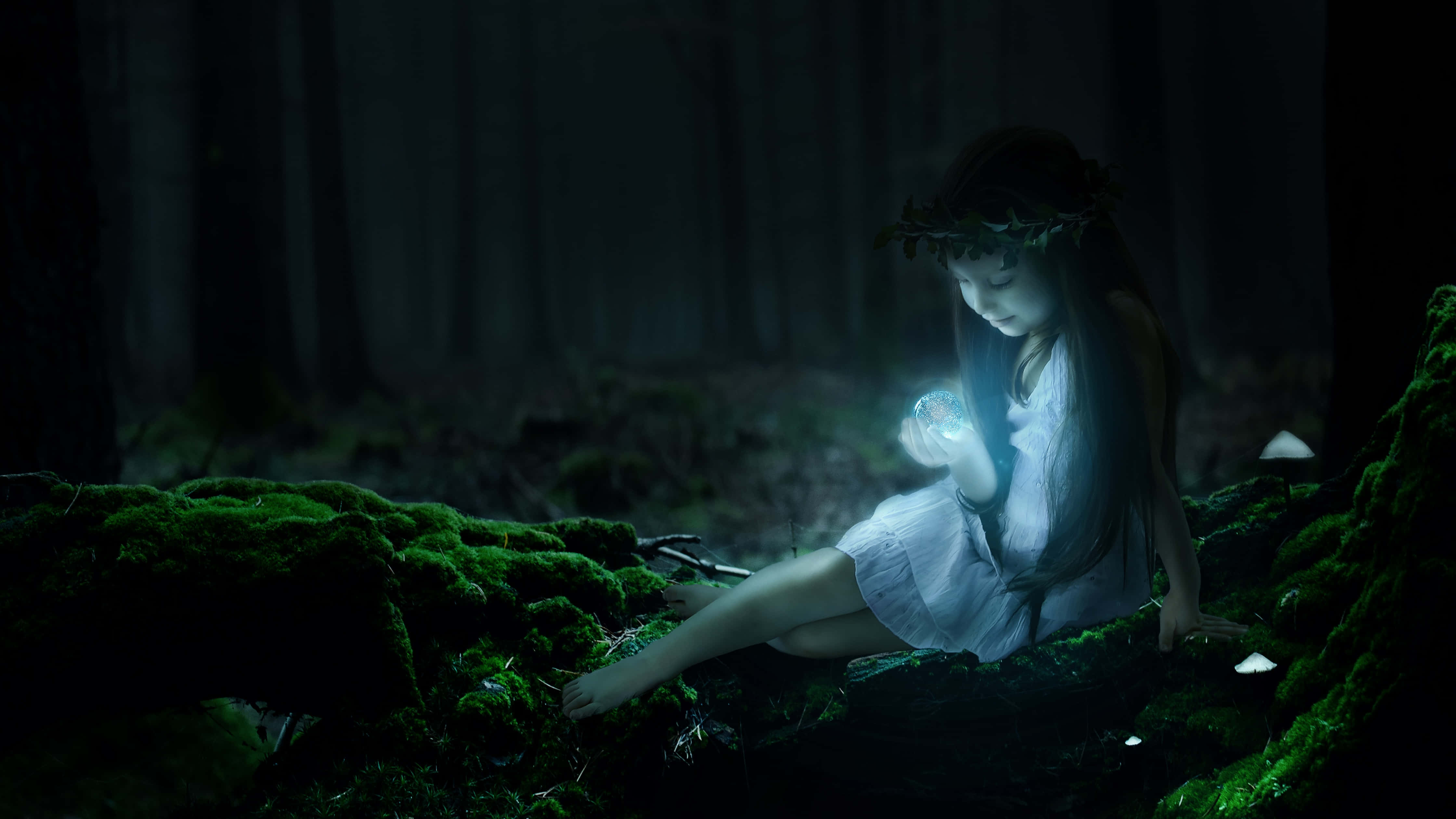 Magical Forest 桌布 壁紙 — 一個穿著白色連衣裙的小女孩坐在黑暗森林中長滿苔蘚的木頭上，手持一個發光的球體，照亮了她的臉龐和周圍環境。