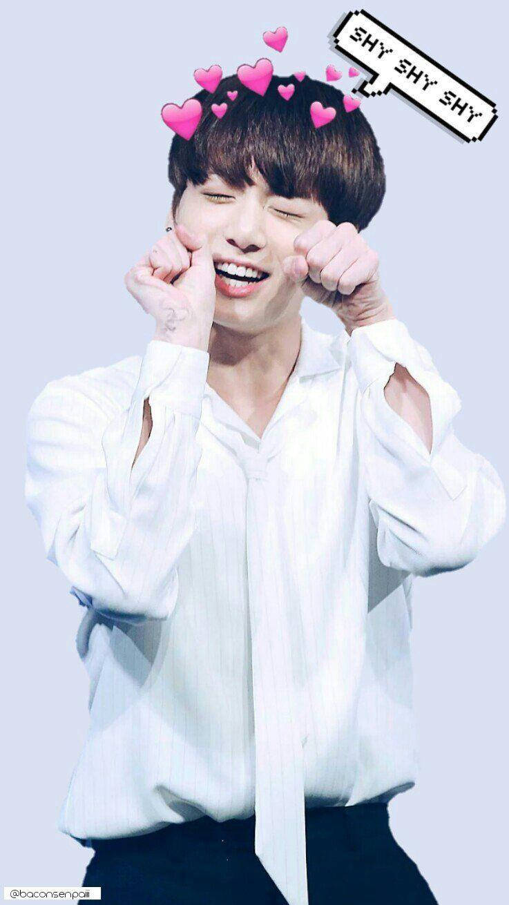 Jungkook Aesthetic 桌布 壁紙 — 一個穿著白襯衫的年輕男子頑皮地用拳頭遮住眼睛，粉紅色的心形漂浮在他的頭頂上。