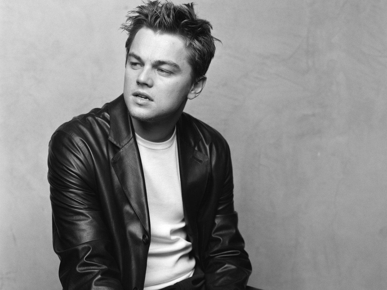 Dicaprio 桌布 壁紙 — 一個穿著皮夾克的年輕男子的黑白肖像，他側視著，表情若有所思。