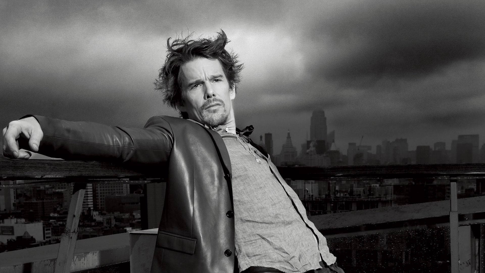 ethan hawke 桌布 壁紙 — 一個穿著皮夾克的男人靠在屋頂欄杆上，背後是暴風雨天空下戲劇性的城市天際線。