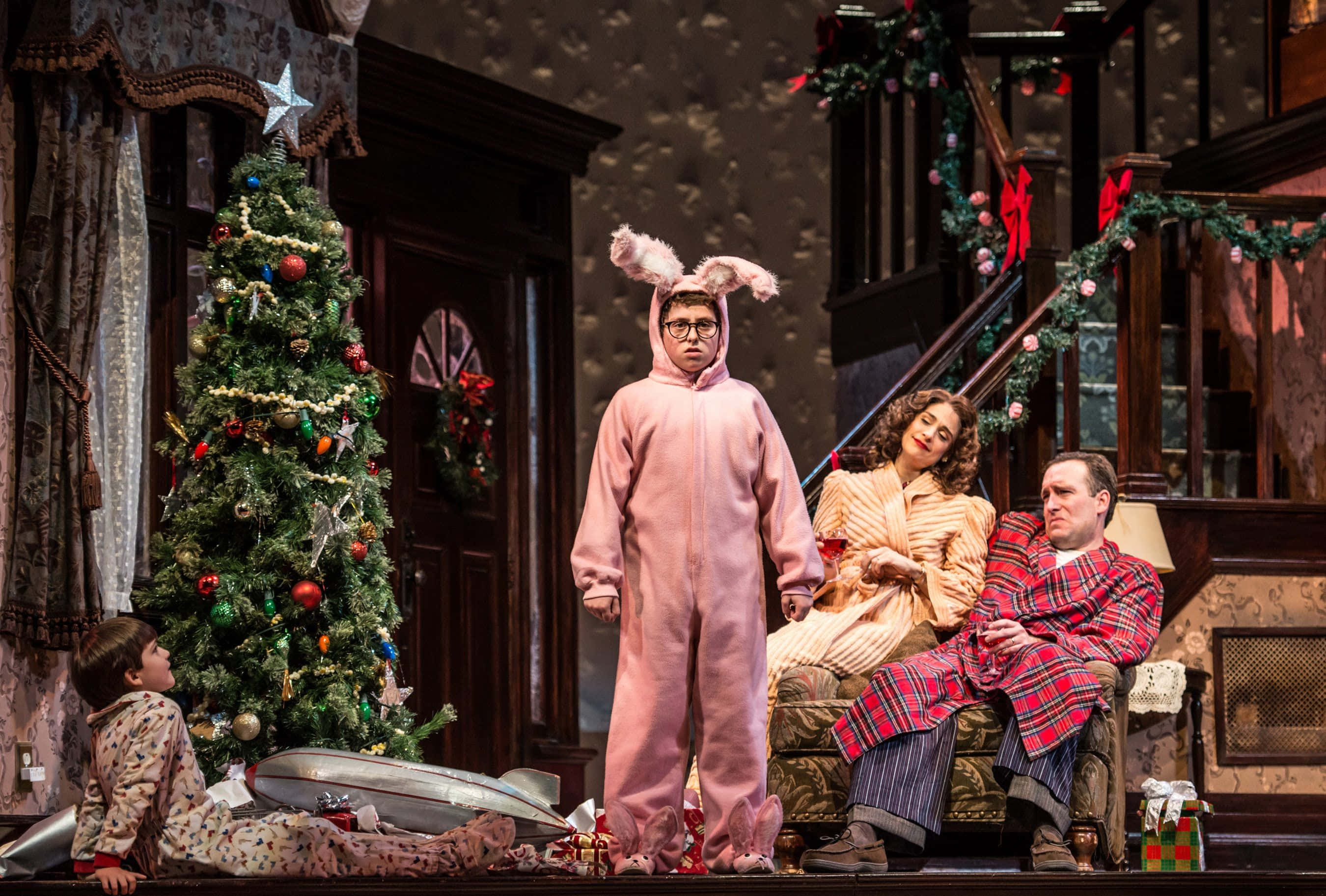 a christmas story 桌布 壁紙 — 一個穿著睡衣和節日服裝的家庭在溫暖照明的復古客廳中聚集在裝飾好的聖誕樹周圍。