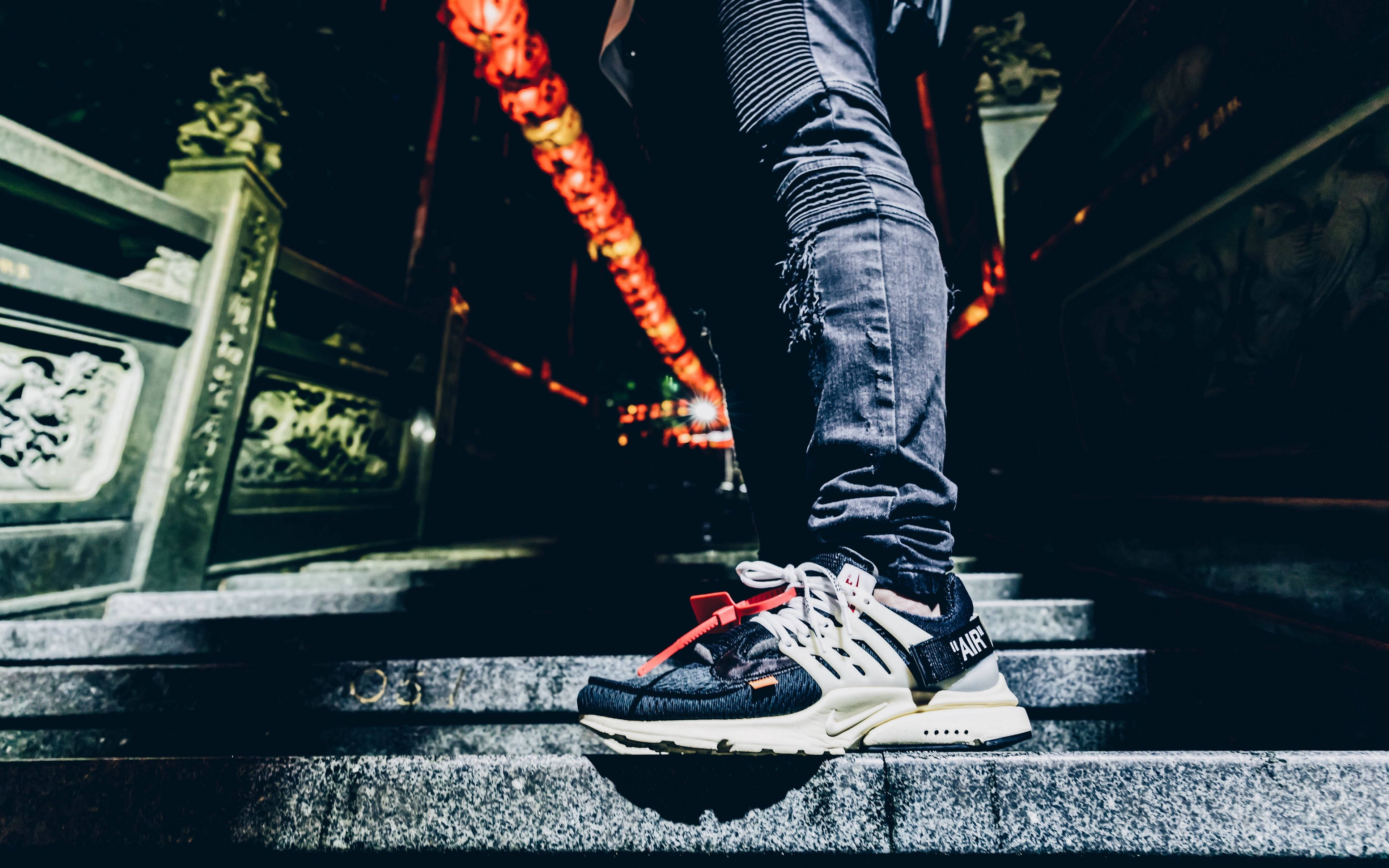 Sneaker 桌布 壁紙 — 一個穿著破洞牛仔褲和醒目運動鞋的人，夜晚站在石階上，上方掛著發光的紅燈籠。