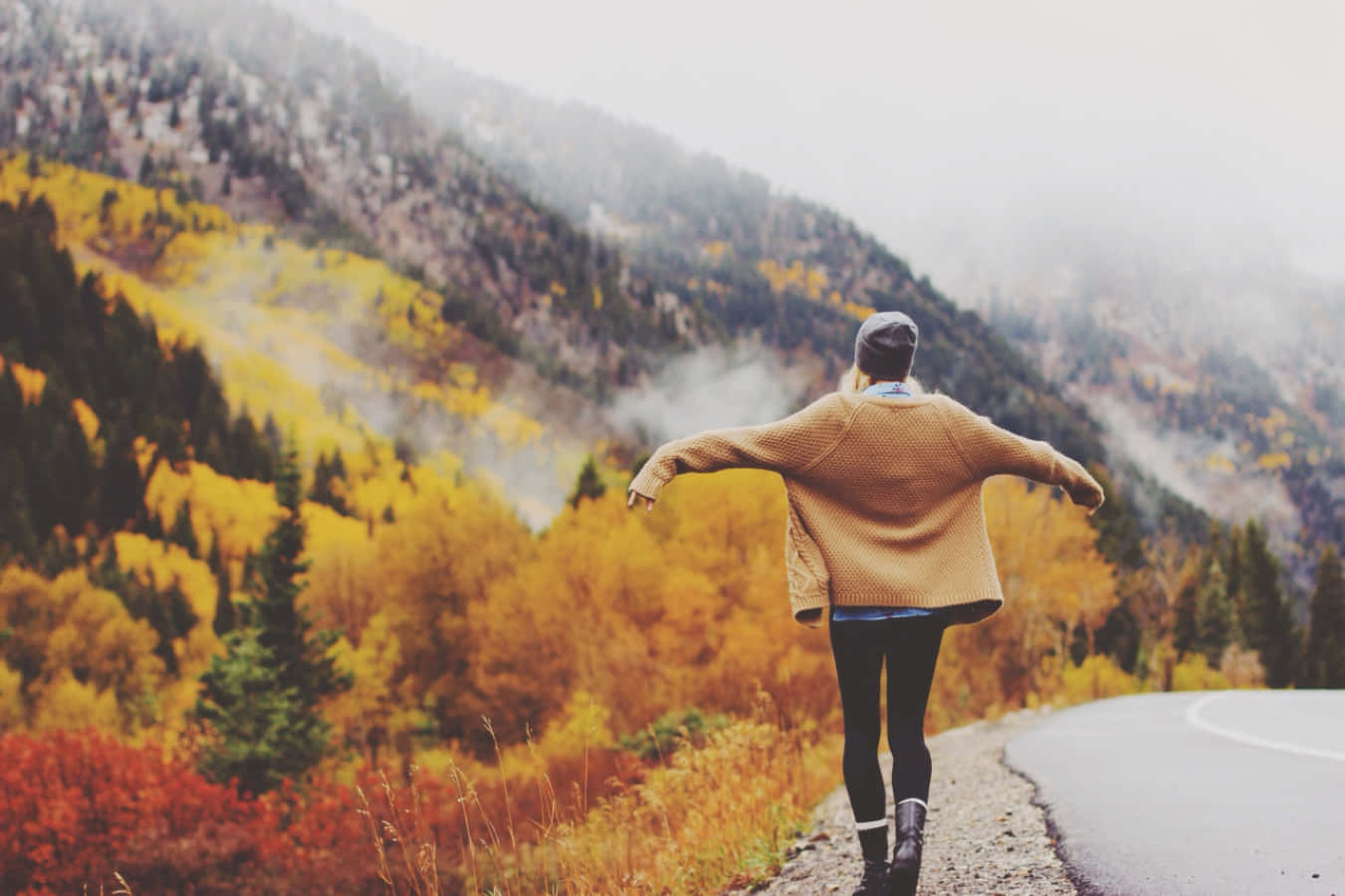 Fall Hikes 桌布 壁紙 — 一個穿著米色毛衣的人在一條被秋葉和霧氣籠罩的山路上張開雙臂站著。