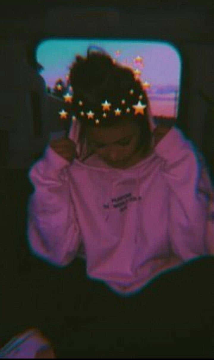 Pretty Girl Aesthetic 桌布 壁紙 — 一個穿著粉紅色連帽衫的人坐在車內，帶有星星濾鏡疊加，透過車窗凝視著暮色天空。