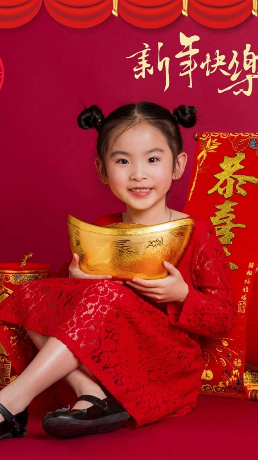 桌布 壁紙 — 一個穿著紅色傳統裙子的快樂小女孩，在帶有農曆新年裝飾的喜慶紅色背景前拿著金條。