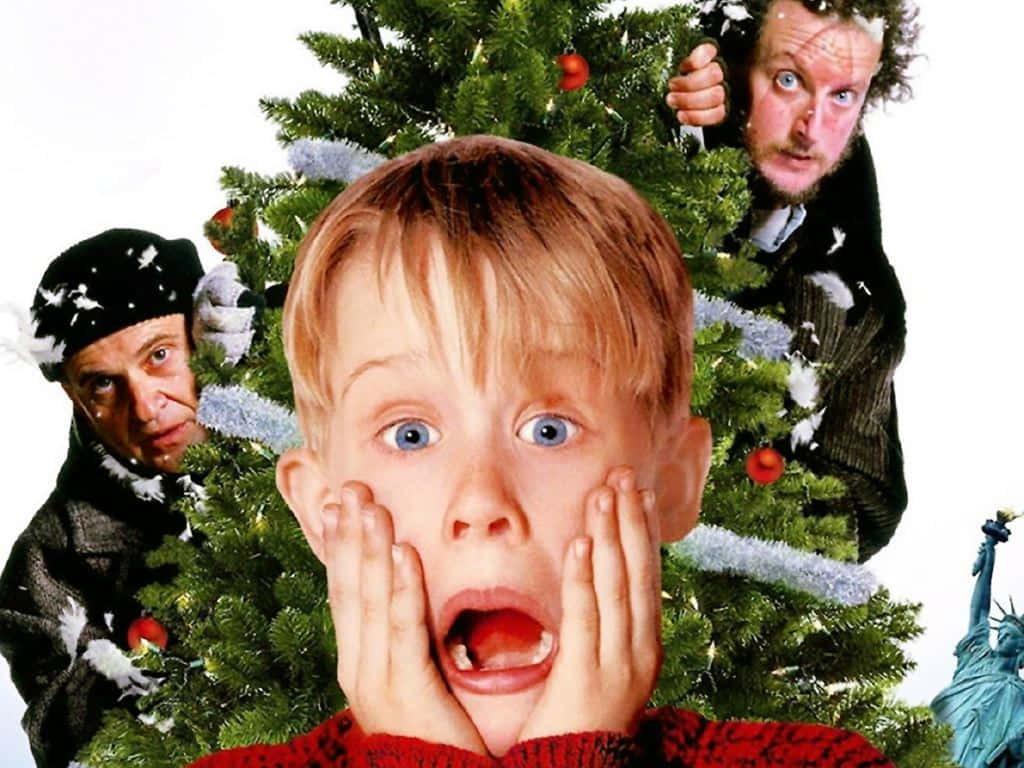 Home Alone 桌布 壁紙 — 一個穿著紅色毛衣、睜大眼睛的男孩震驚地倒吸一口氣，因為兩個男人從裝飾好的聖誕樹後面偷看。