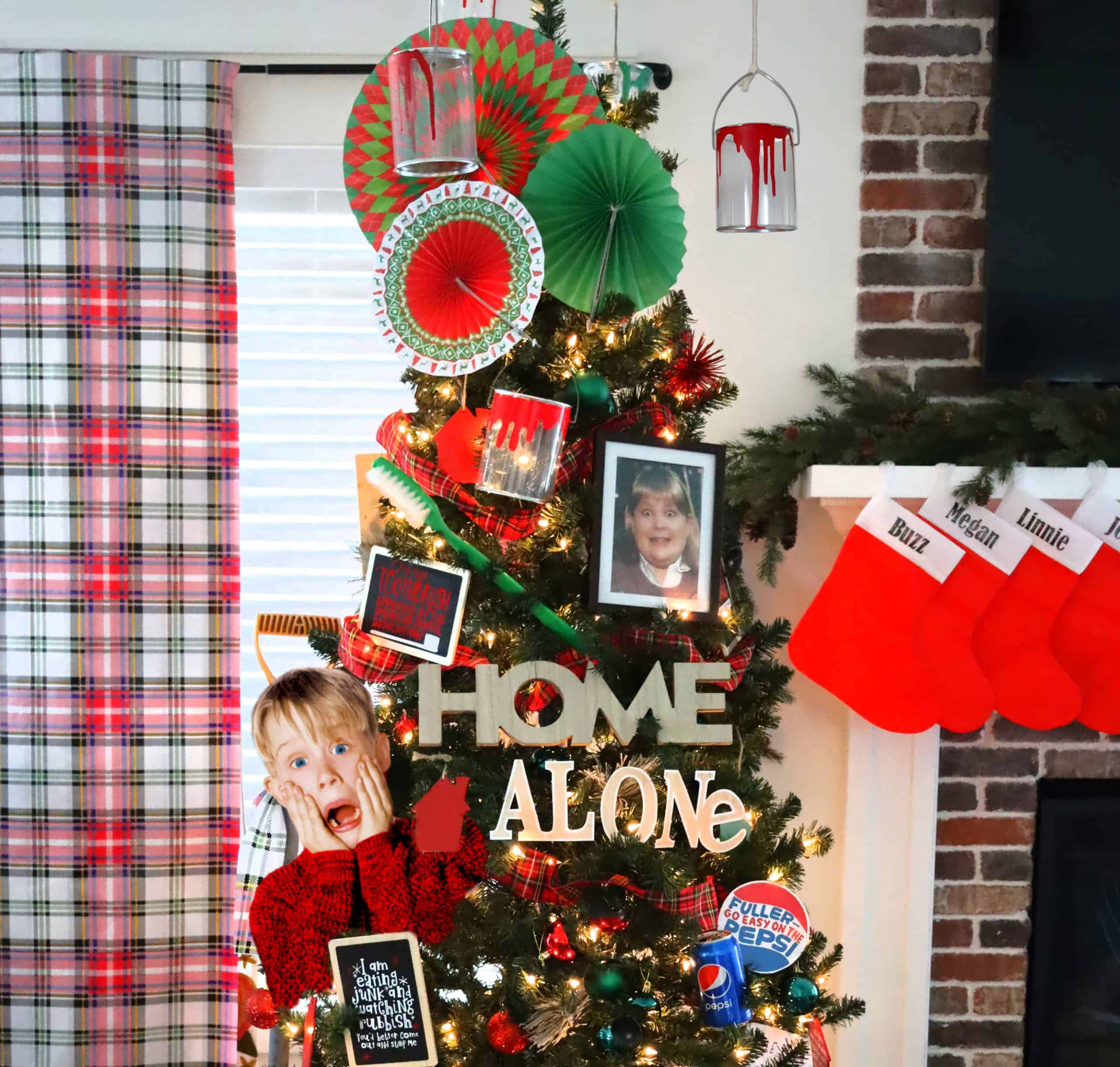 Home Alone 桌布 壁紙 — 一個穿著紅色毛衣的孩子在聖誕樹旁邊顯得震驚，聖誕樹上裝飾著《小鬼當家》電影道具和格子圖案。