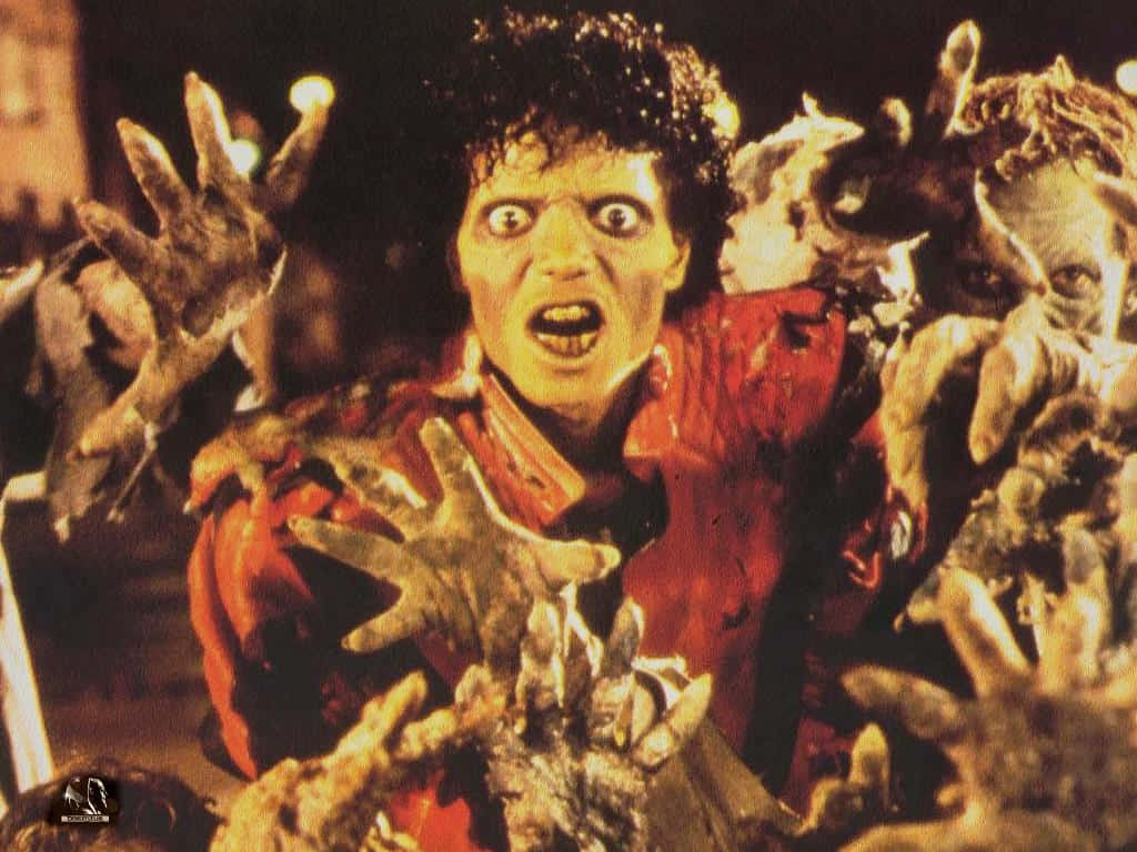 Michael Jackson Thriller 桌布 壁紙 — 一個穿著紅色襯衫的驚恐男子，在黑暗恐怖的場景中被伸向他的怪誕殭屍手包圍。
