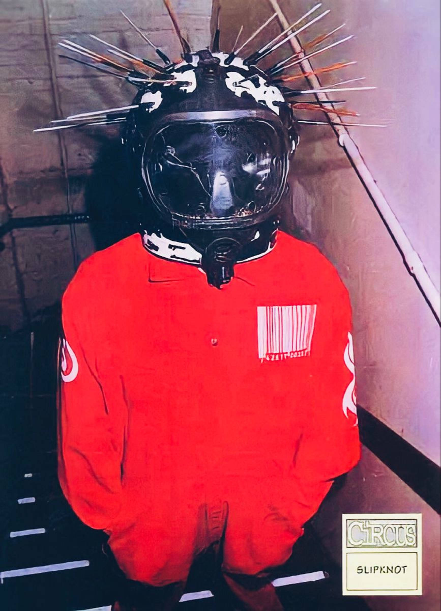 craig jones 桌布 壁紙 — 一個穿著紅色連身衣和尖刺頭盔的人站在光線昏暗的工業走廊中。