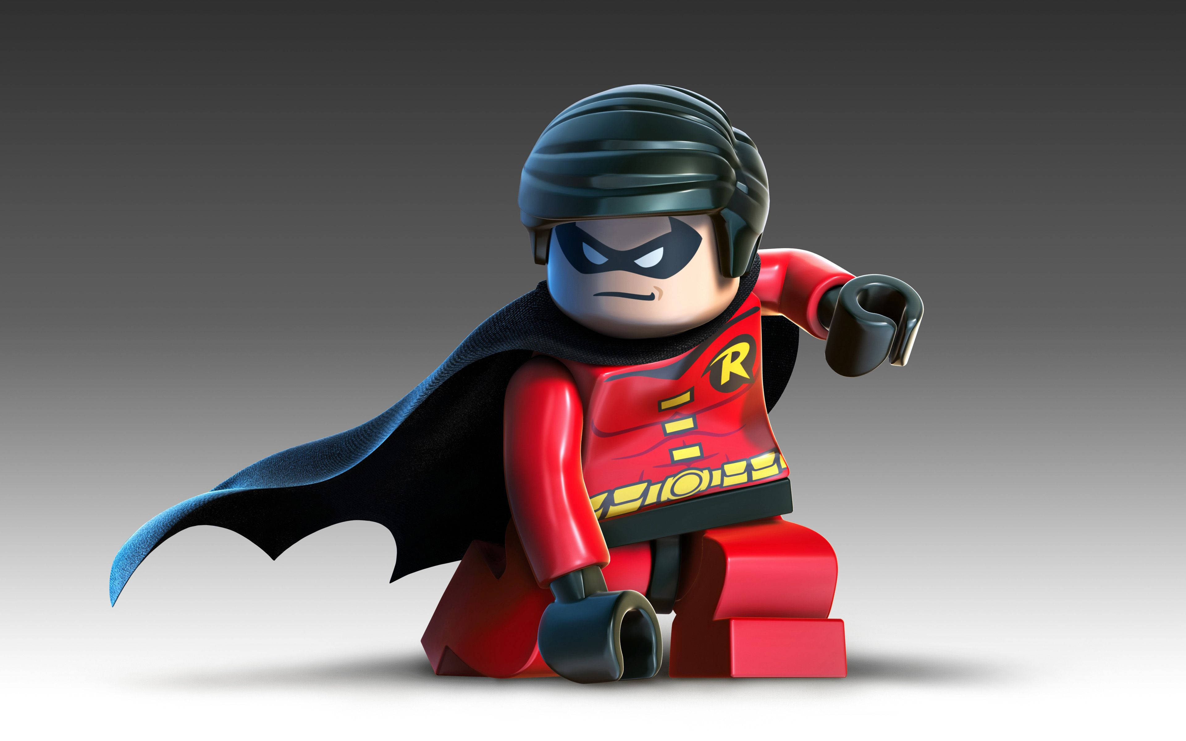 樂高 桌布 壁紙 — 一個穿著紅黑套裝和披風的LEGO Robin人偶，在灰色漸變背景前動態擺姿勢。