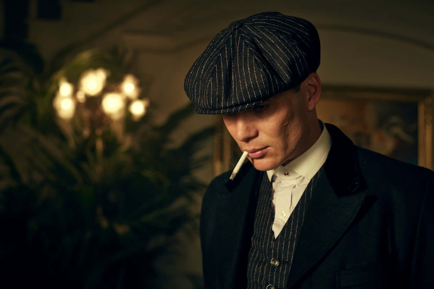 穿著復古西裝和帽子的男人在室內抽煙，有溫暖的燈光。 — Peaky Blinders 壁紙