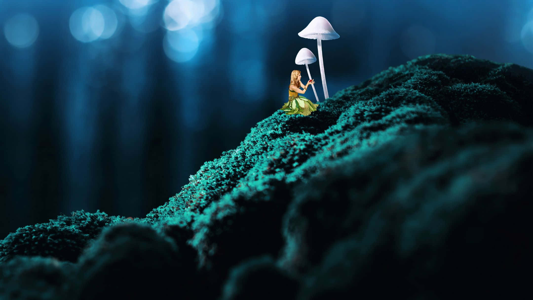 酷 桌布 壁紙 — 一個穿著綠色連衣裙的小人物坐在藍色森林散景下的苔蘚山丘上，旁邊是發光的蘑菇。