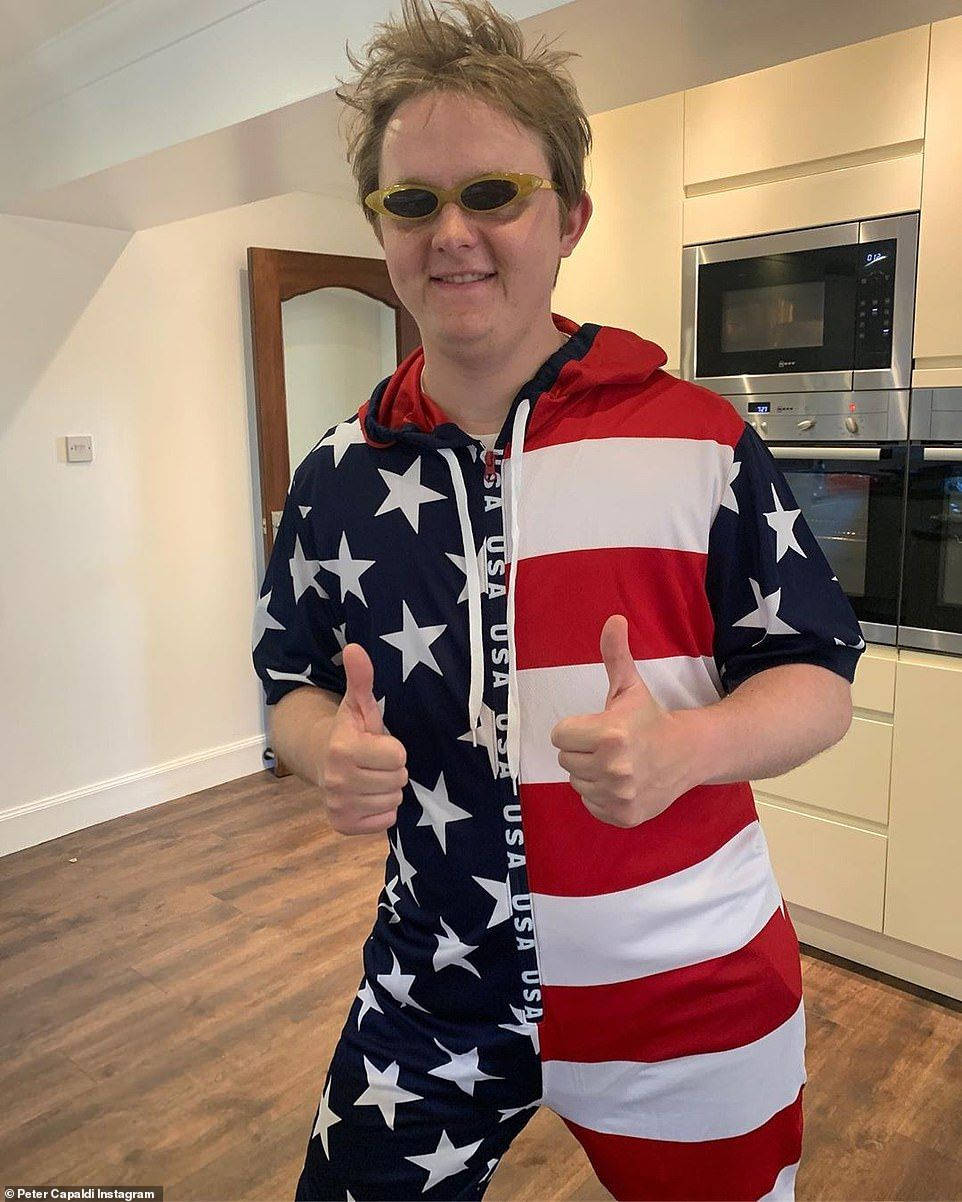Lewis Capaldi 桌布 壁紙 — 一個穿著美國國旗連身衣的人在現代廚房裡豎起兩個大拇指，廚房裡有不鏽鋼電器。