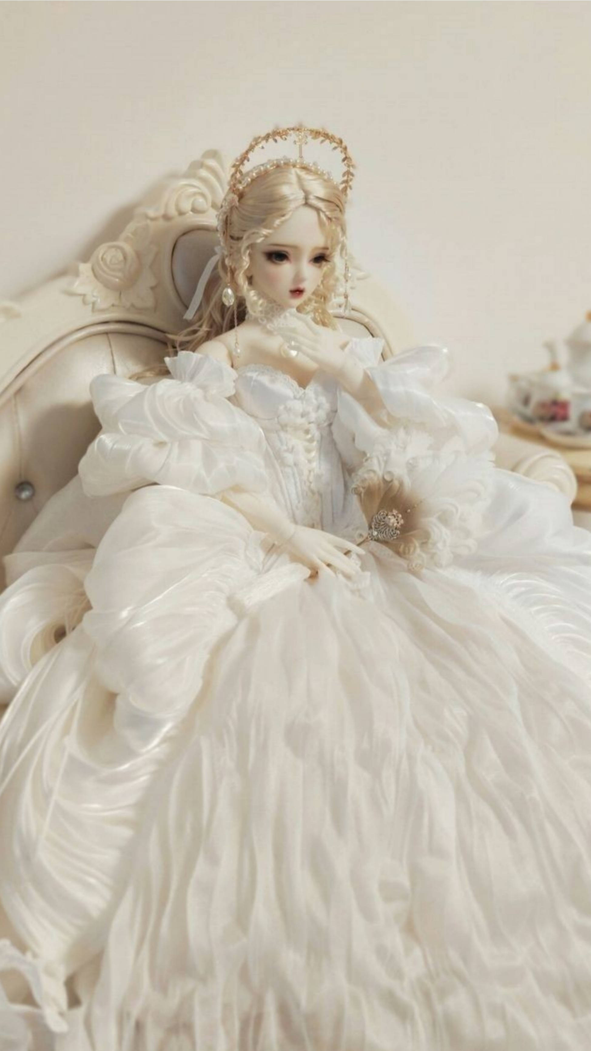 Princess 桌布 壁紙 — 一個穿著華麗白色長袍的瓷娃娃，端莊地坐在一張華麗的奶油色椅子上，手持一把精緻的扇子。