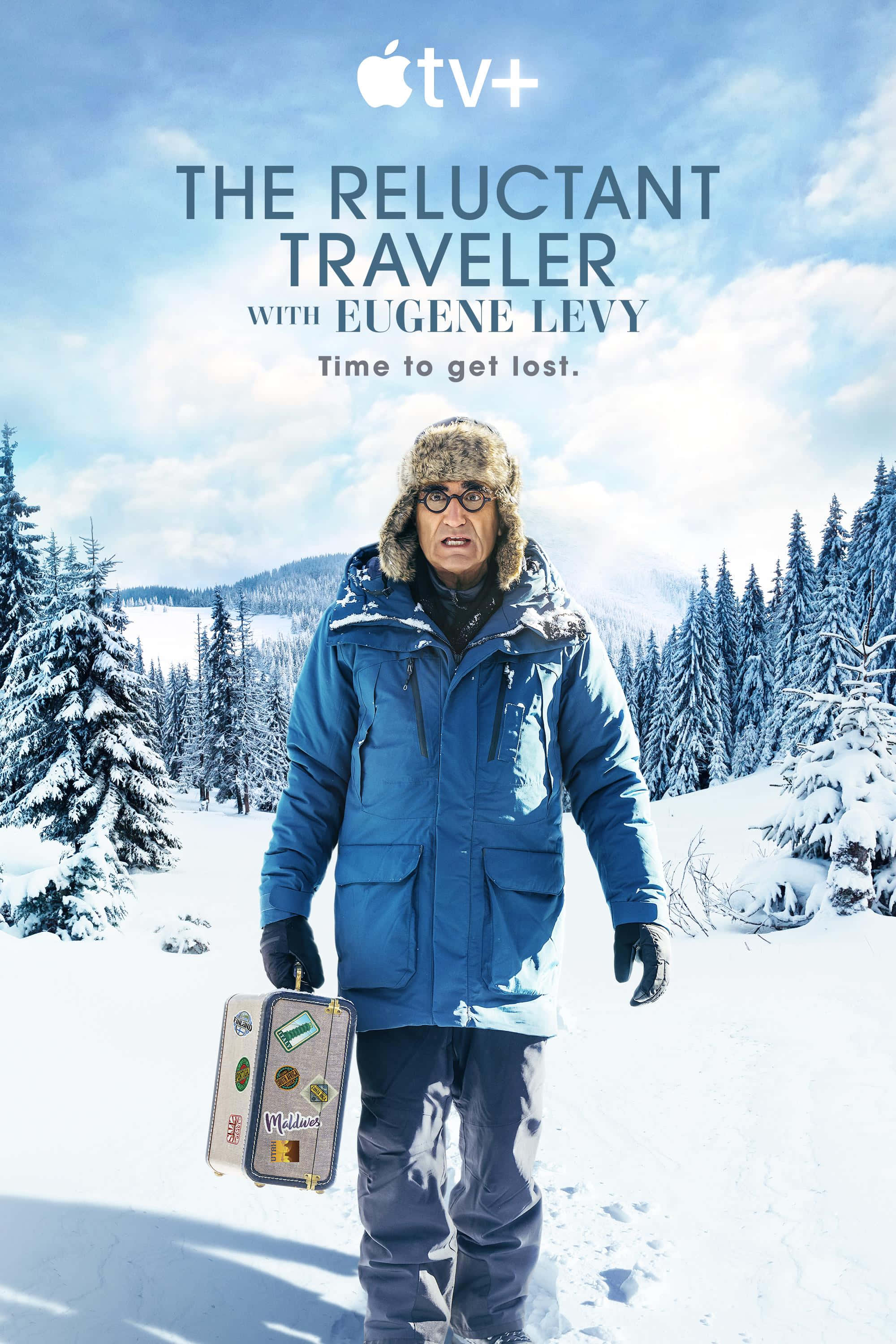 Man 桌布 壁紙 — 一個穿著藍色冬季外套和毛帽的男人，穿過雪地森林，手持一個貼滿旅行貼紙的復古手提箱。