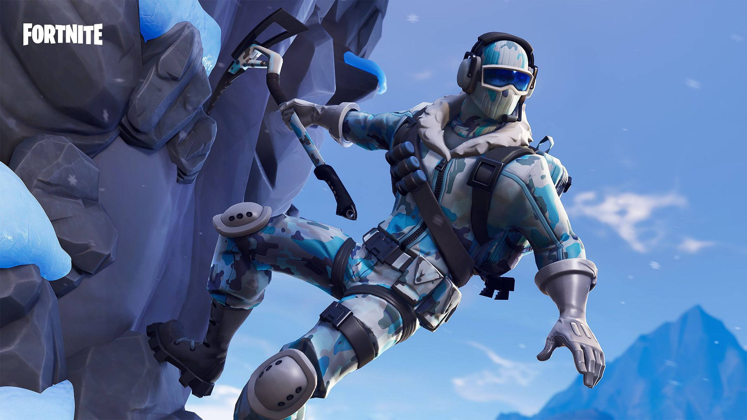 Fortnite 桌布 壁紙 — 一個穿著藍色迷彩裝備的Fortnite角色在明亮的藍天下攀爬積雪的懸崖，遠方有山脈。