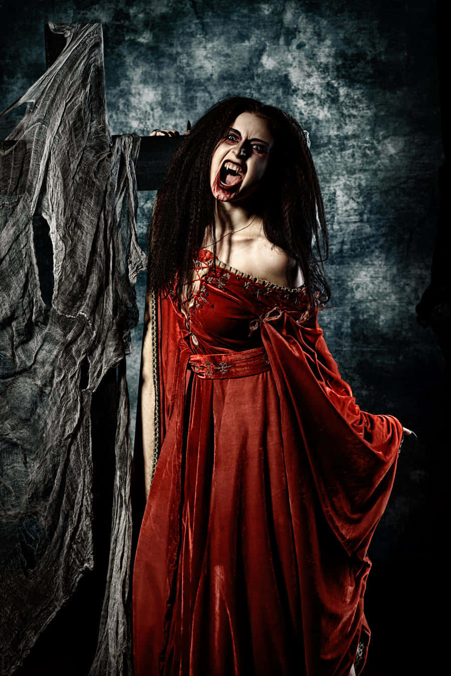 Dark Vampire 桌布 壁紙 — 一個穿著血跡斑斑紅色長袍的女人，對著黑暗紋理背景，睜著狂野的眼睛尖叫。