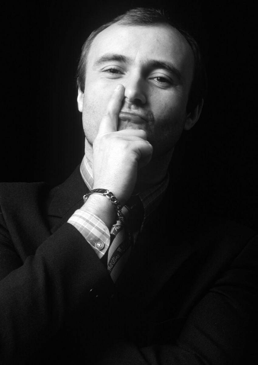 actor 桌布 壁紙 — 一個穿著西裝的男人在黑暗背景前將手指放在嘴唇上的黑白肖像。
