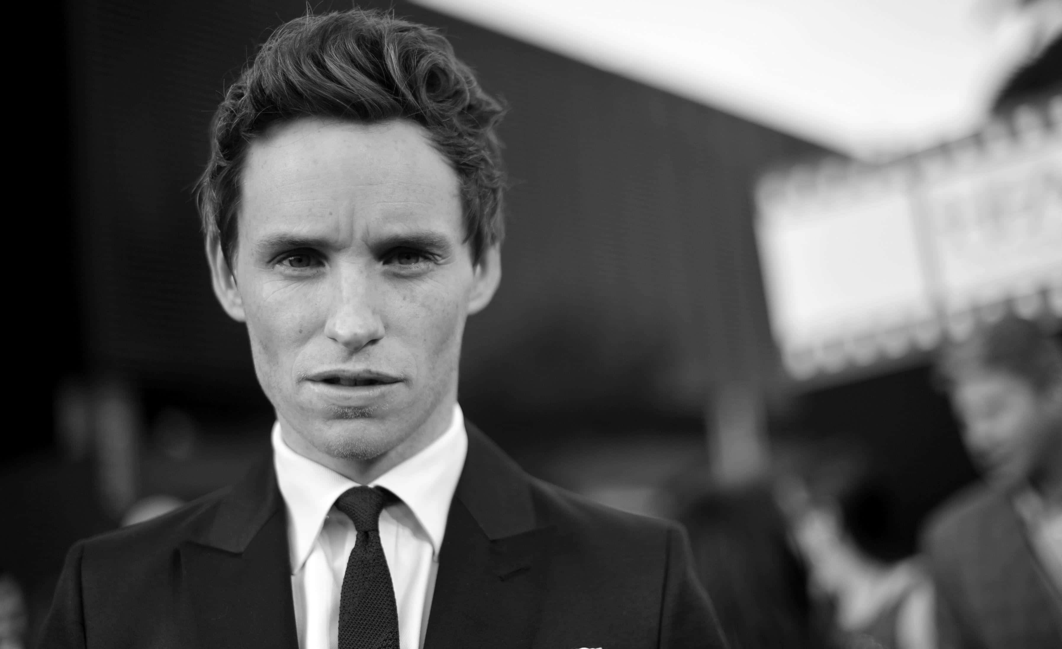 eddie redmayne 桌布 壁紙 — 一個穿著西裝的男人直接看著相機，表情嚴肅的黑白特寫肖像。