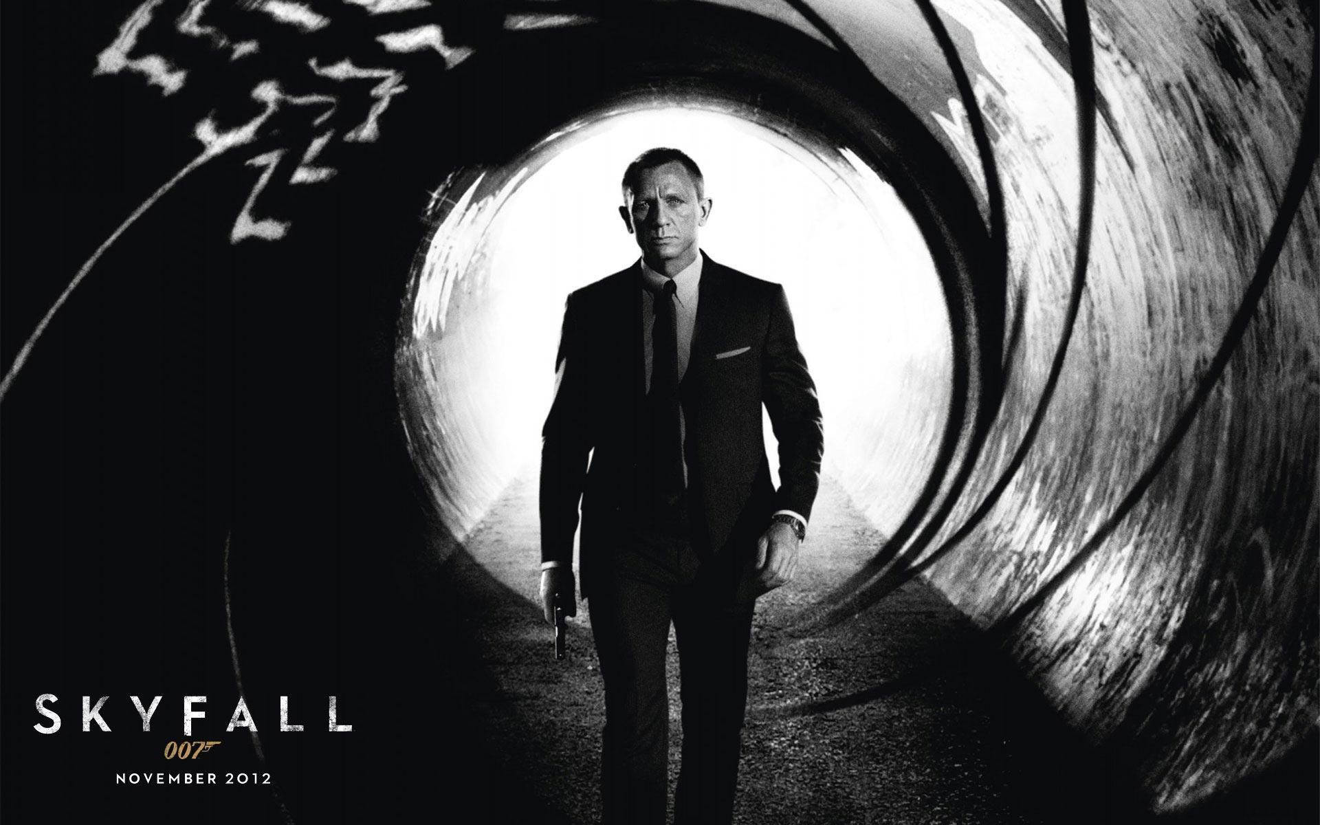 Bond 桌布 壁紙 — 一個穿著西裝的男人站在隧道裡，手持槍支，被一個發光的圓形開口框住，黑白畫面。