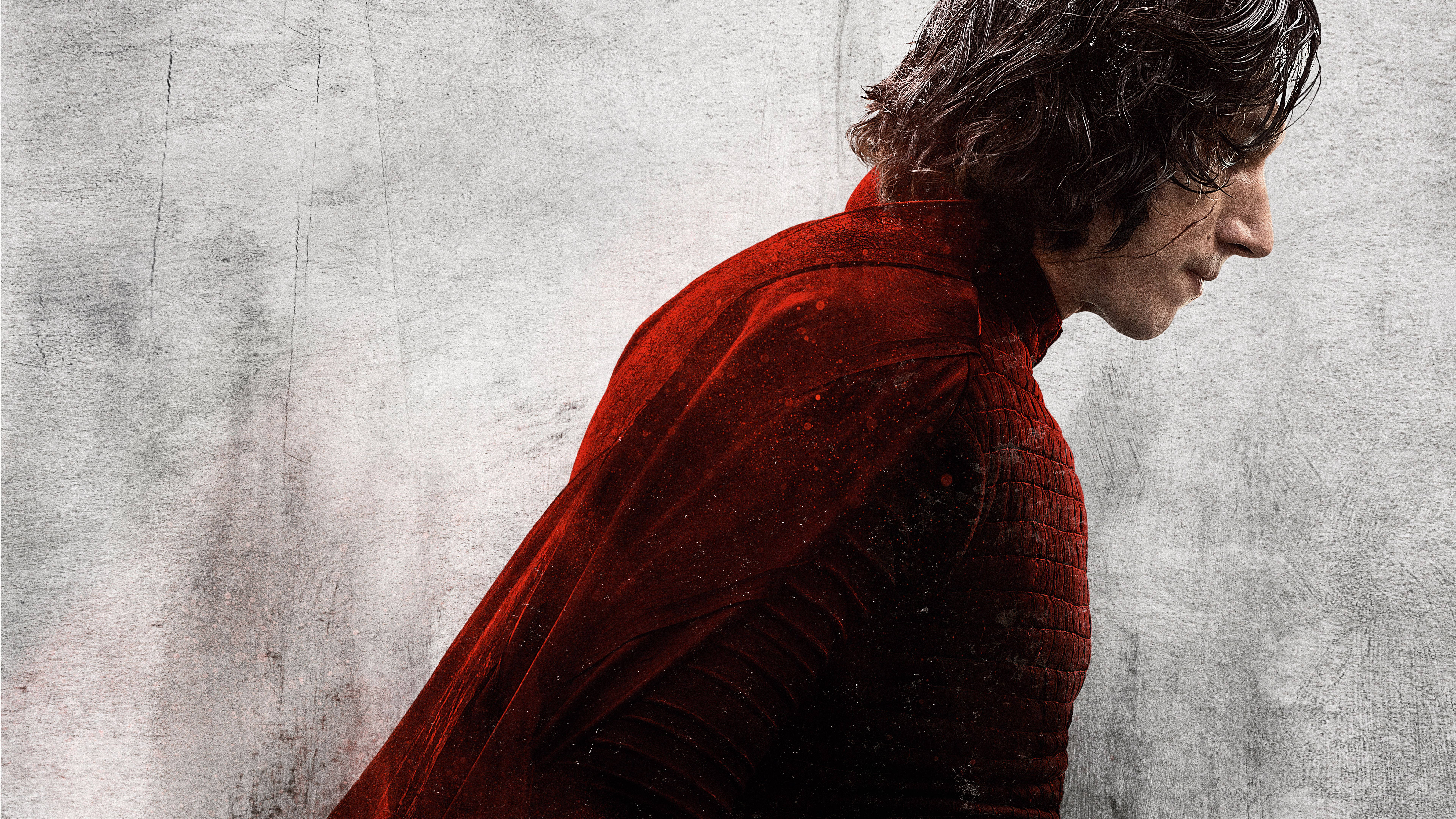 Kylo Ren 桌布 壁紙 — 一個穿著質感紅色長袍的男人側身站在風化的灰色牆壁前，目光低垂，陷入靜默的沉思。