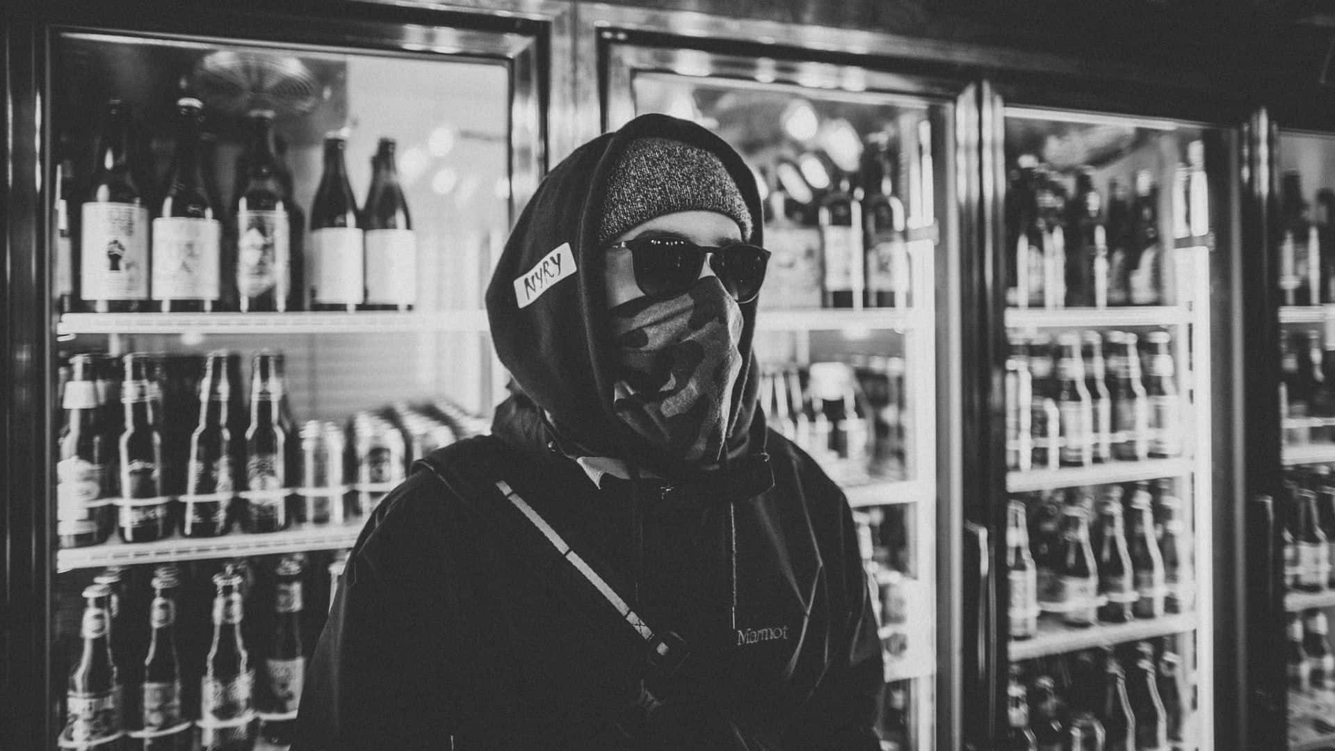 Gang 桌布 壁紙 — 一個穿著連帽衫和太陽眼鏡的人站在昏暗酒吧的冷藏啤酒架前。