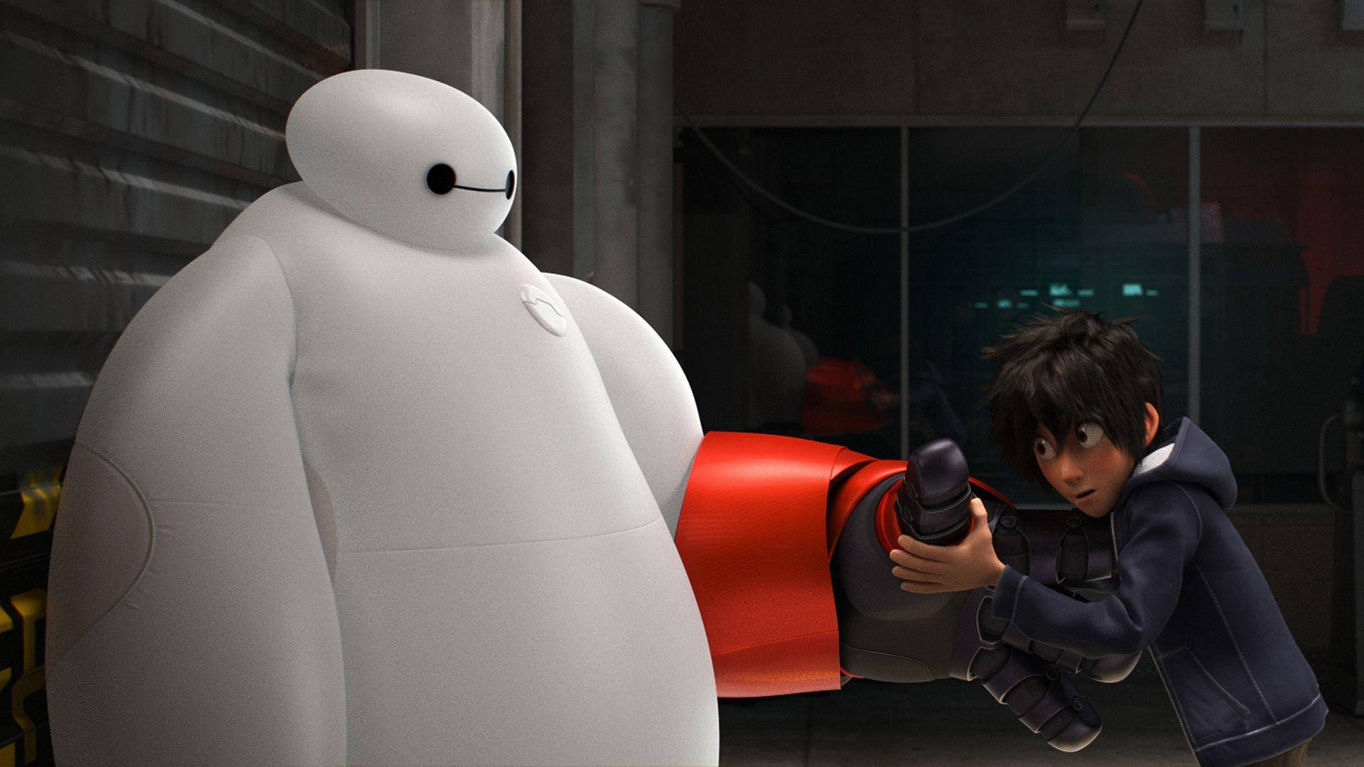 Baymax 桌布 壁紙 — 一個穿著連帽衫的男孩在昏暗的工業環境中抓住一個巨大的白色充氣機器人的紅色手臂。
