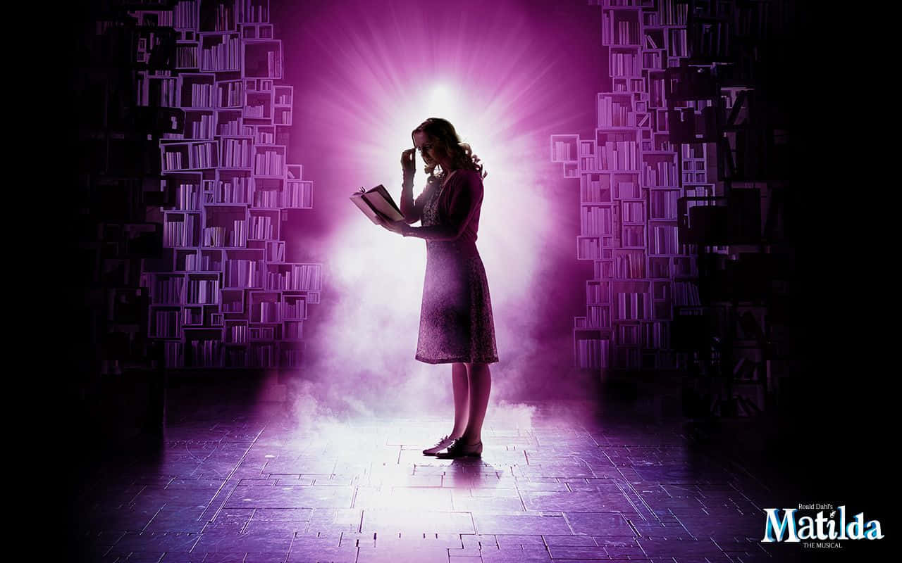 Musical 桌布 壁紙 — 一個穿著連衣裙的女孩站在紫色燈光下，手持一本書，周圍是高聳的書架。