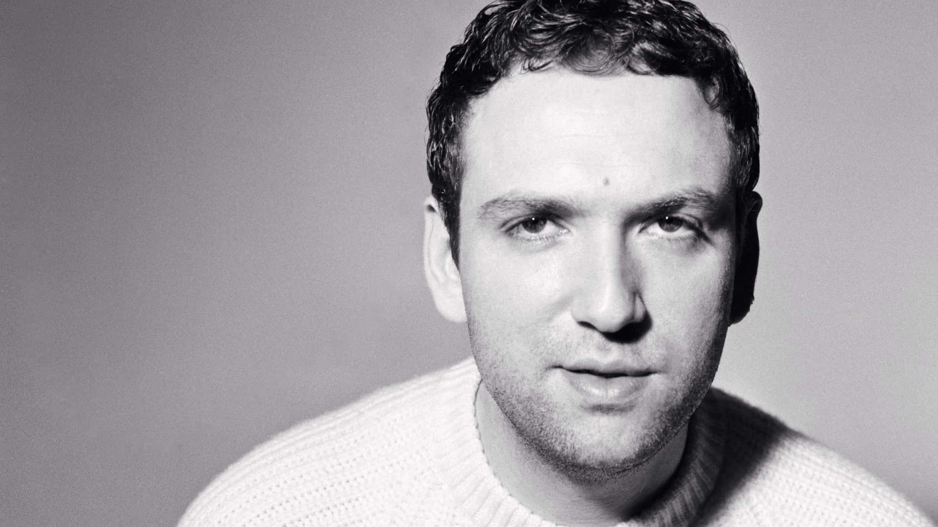 風景 桌布 壁紙 — 一個穿著針織毛衣的男人黑白肖像，直視鏡頭，表情中性。