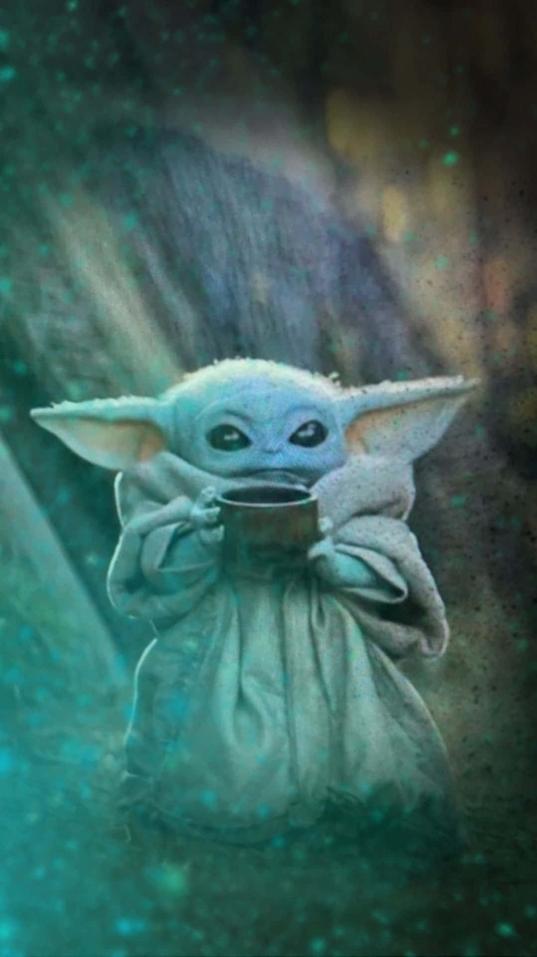 Baby Yoda iPhone 桌布 壁紙 — 一個穿著長袍的細小藍色嬰兒外星人拿著一個杯子，發光粒子在黑暗神秘的環境中漂浮。