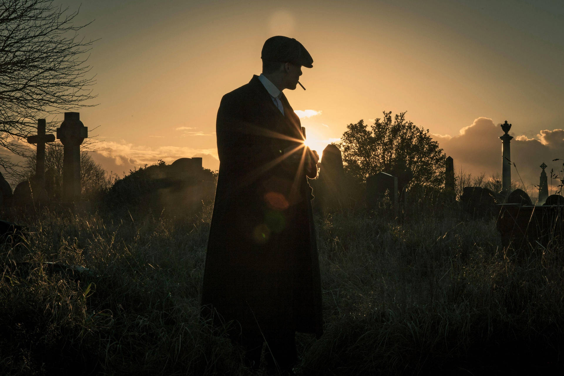 穿風衣的男人在金色日落墓地抽煙。 — Peaky Blinders 壁紙