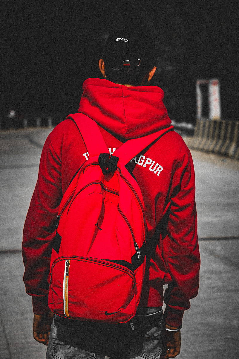 穿著紅色連帽衫和背包的人在夜間城市街道上走開。 — 單身男孩 壁紙