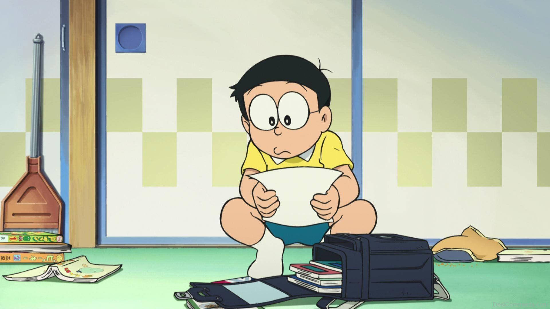 nobita 桌布 壁紙 — 一個穿著黃色襯衫的小男孩蹲在綠色地板上，拿著一張紙，周圍散落著書本和一個背包，在一個格子房間裡。