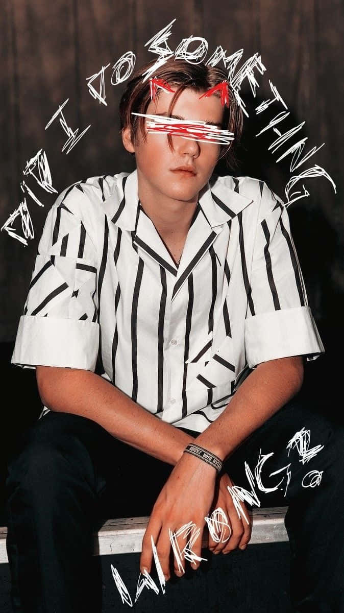 桌布 壁紙 — 一個穿著黑白條紋襯衫的年輕男子坐著，眼睛被紅色塗鴉和圍繞他旋轉的塗鴉文字遮蓋。