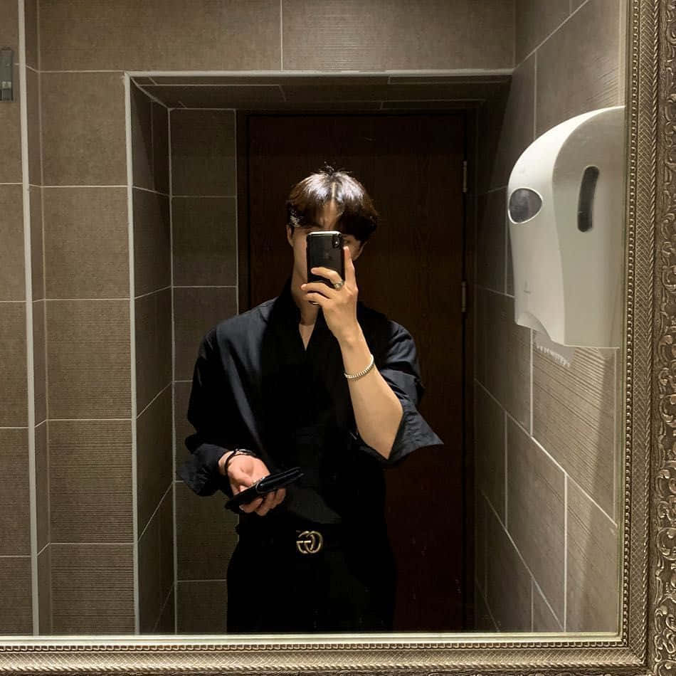 Polo 桌布 壁紙 — 一個穿著黑色服裝的人在有華麗鏡框和紙巾架的瓷磚浴室中自拍鏡像。