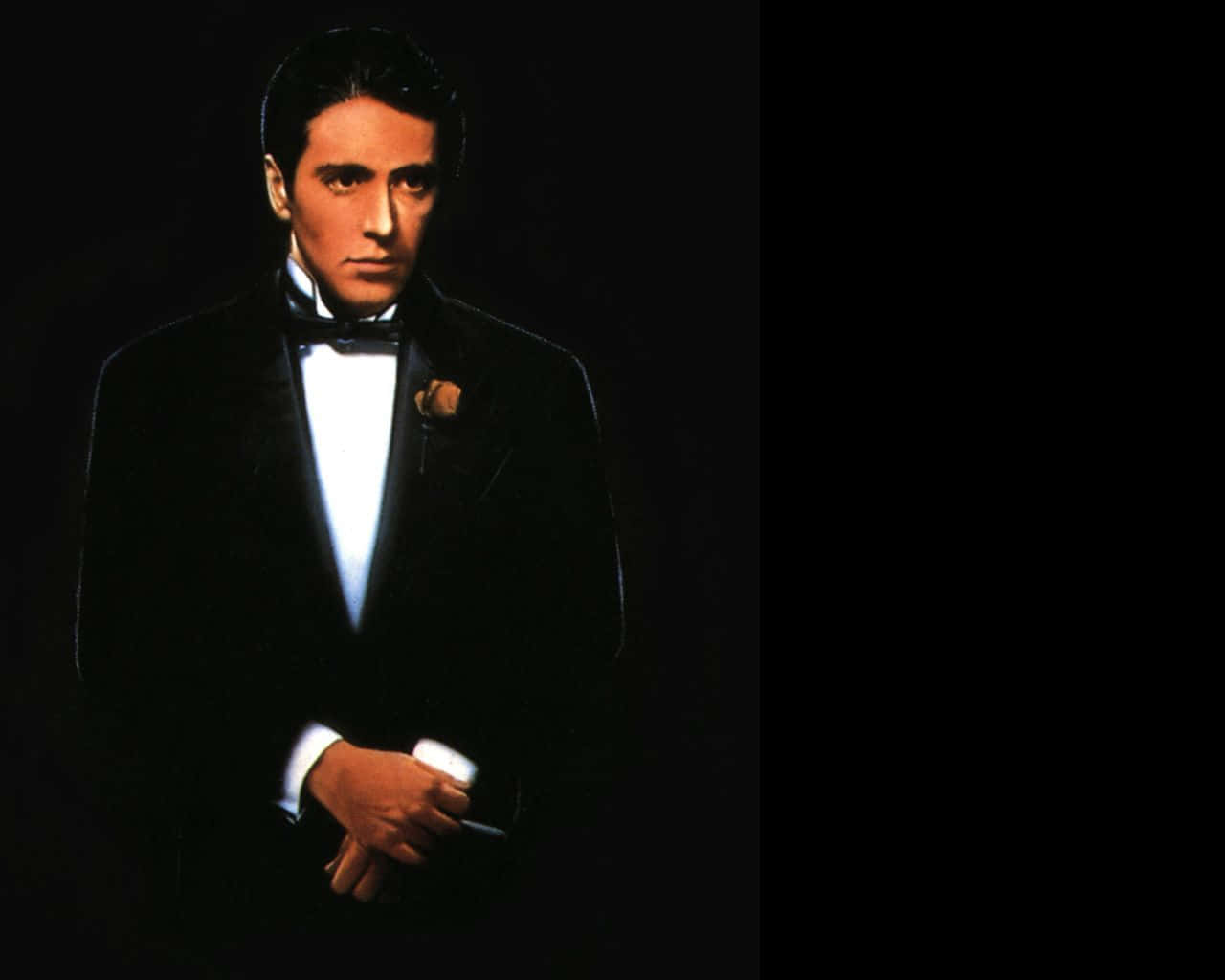 The Godfather 桌布 壁紙 — 一個穿著黑色燕尾服、白色襯衫和領結的男人站在黑暗背景前，手持香煙，表情嚴肅。