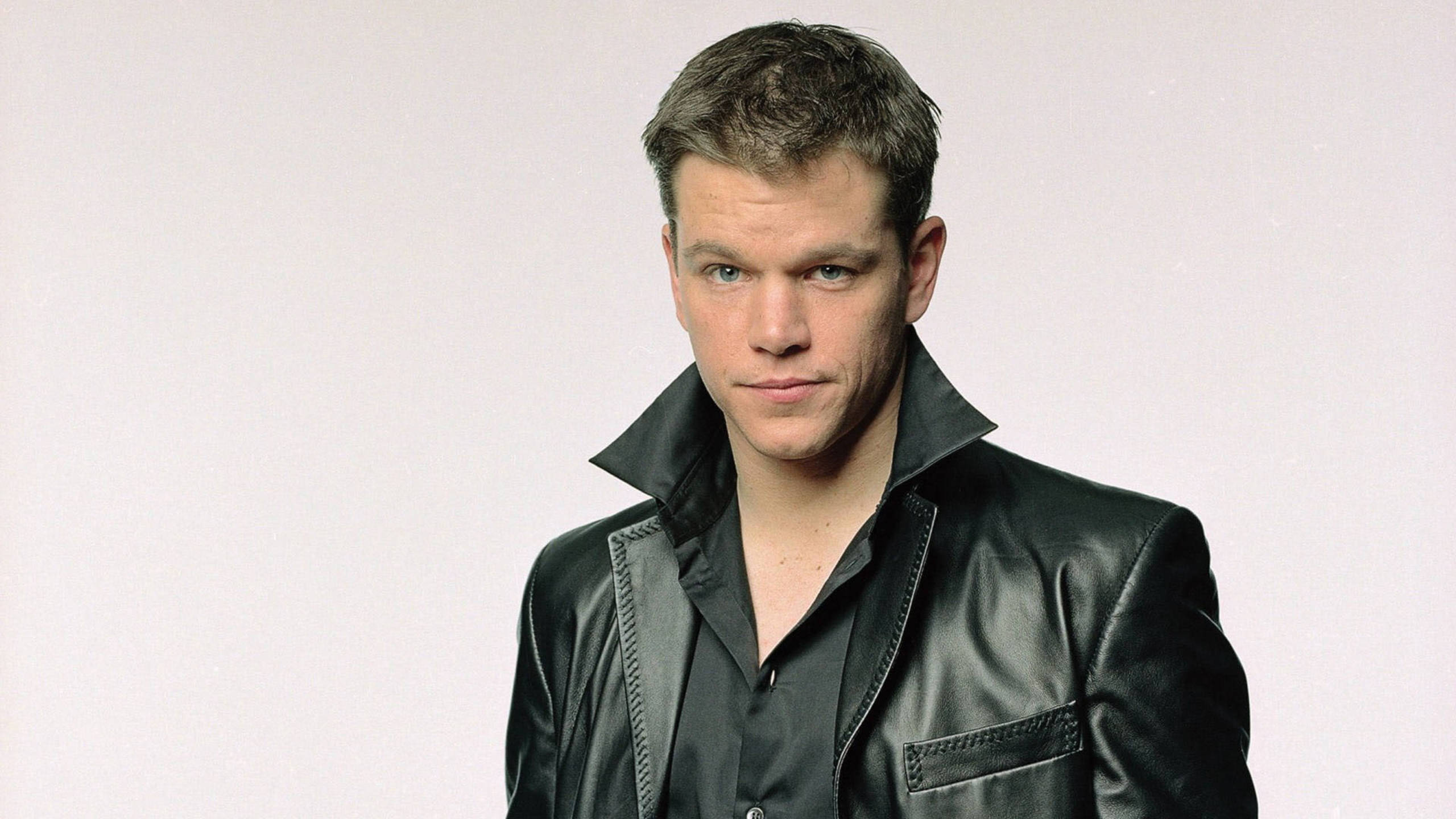 Matt Damon 桌布 壁紙 — 一個穿著黑色皮夾克的男人，在純白色背景前凝視著。