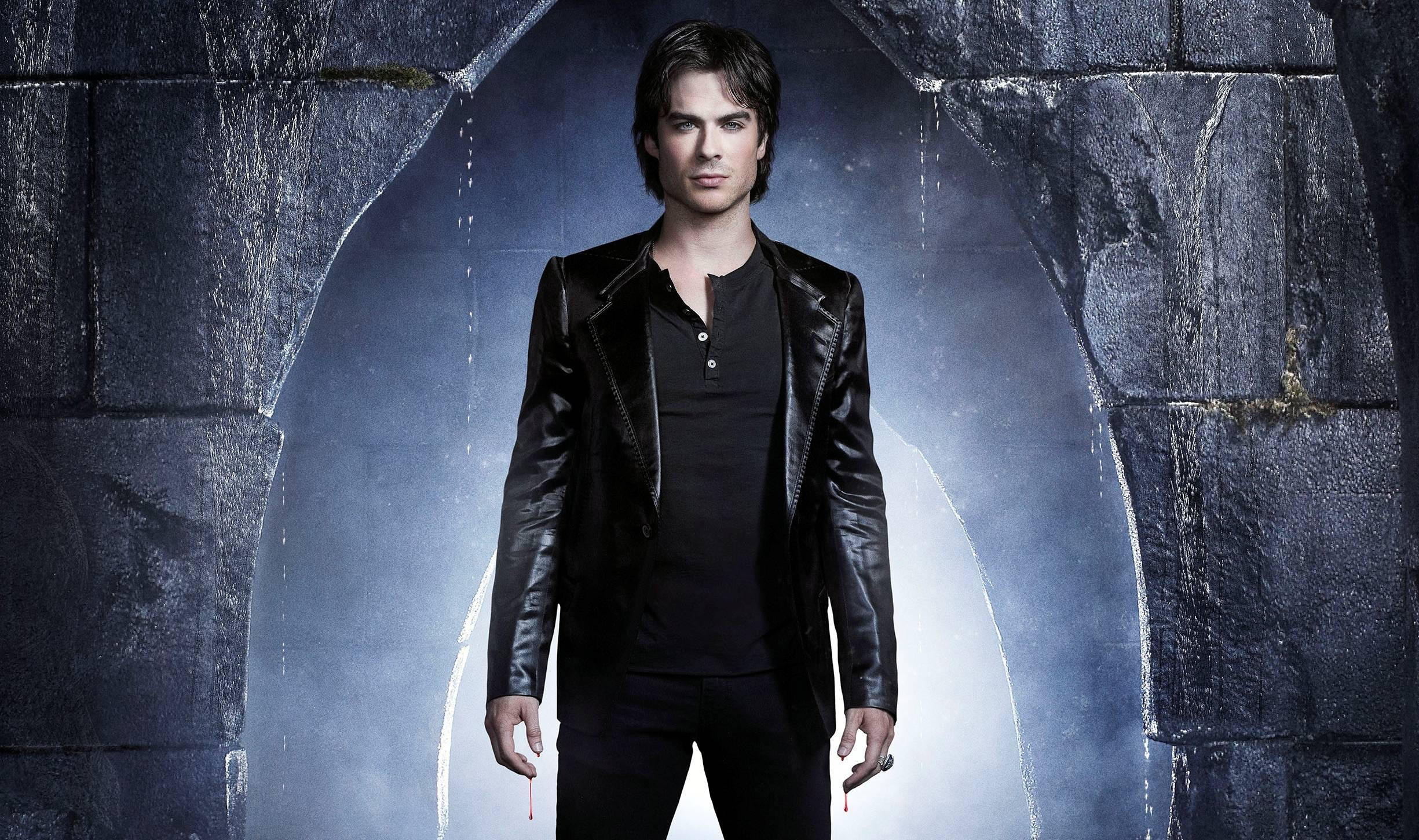 Vampire Diaries 桌布 壁紙 — 一個穿著黑色皮夾克的男人站在一個黑暗的石拱門中，背後有發光的藍光。