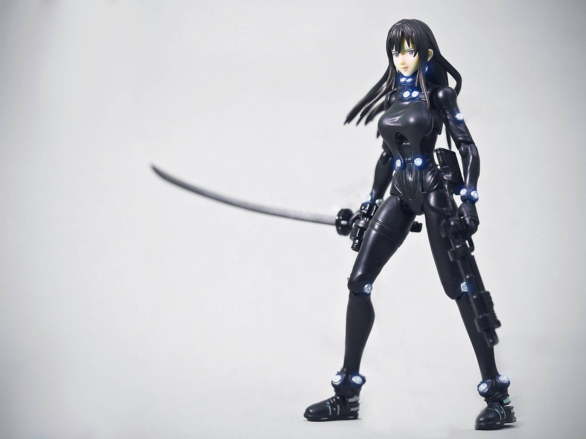 Gantz 桌布 壁紙 — 一個穿著黑色盔甲的動漫動作人偶，長長的黑髮，在純白色背景前揮舞著一把彎曲的劍。