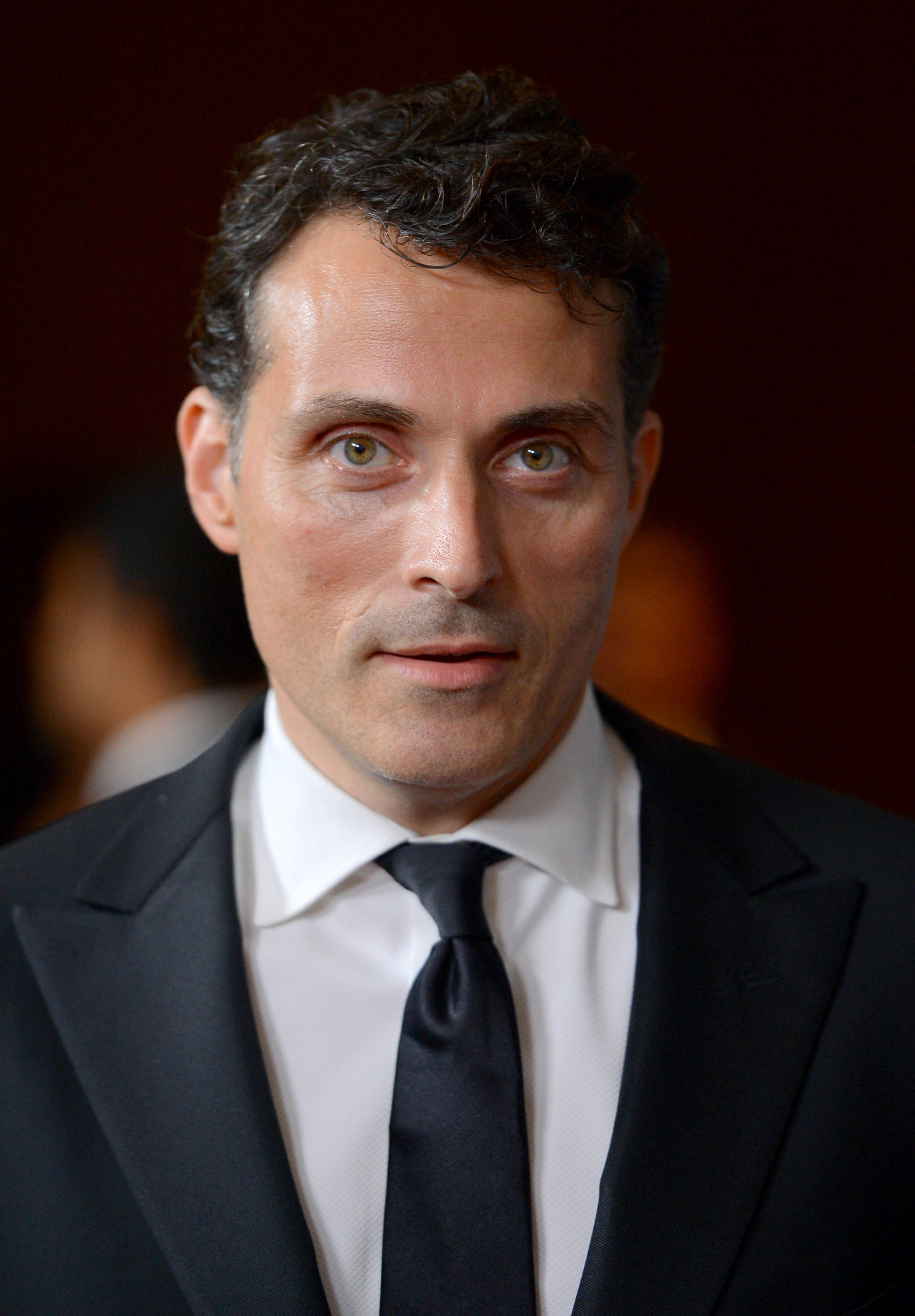 actor 桌布 壁紙 — 一個穿著黑色西裝和領帶的男士特寫肖像，背景是模糊的紅色。