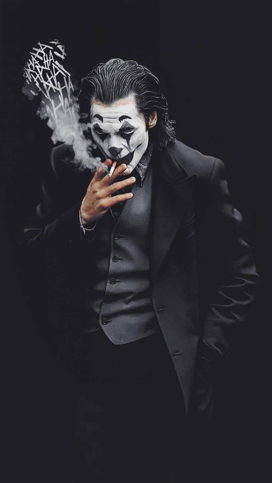 smoker 桌布 壁紙 — 一個穿著黑色西裝的可怕小丑在黑暗背景中吸煙，煙霧繚繞。