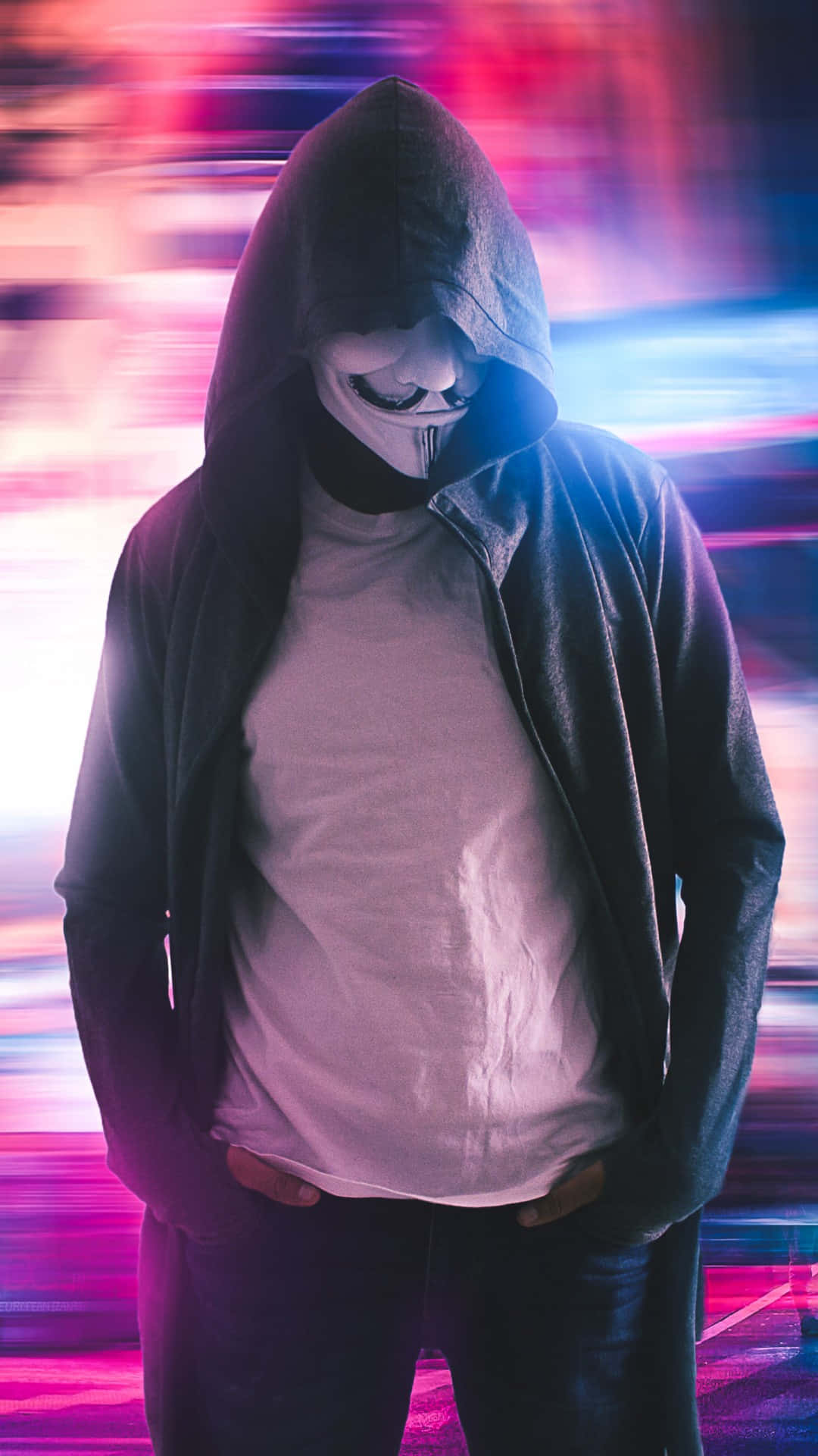 Anonymous iPhone 桌布 壁紙 — 一個穿著黑色連帽衫、戴著V怪客面具的人站在充滿活力的條紋霓虹背景前。