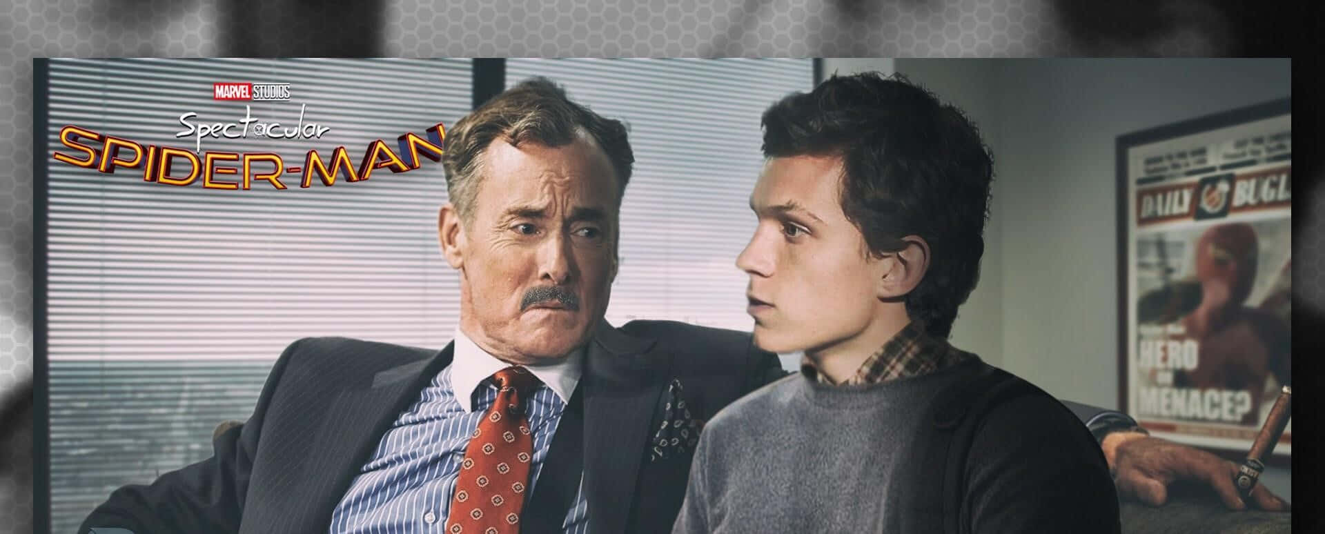 J Jonah Jameson 桌布 壁紙 — 一個穿西裝、留鬍子的男人坐在一個穿灰色毛衣的年輕人身邊，兩人在辦公室場景中專注地互相凝視。