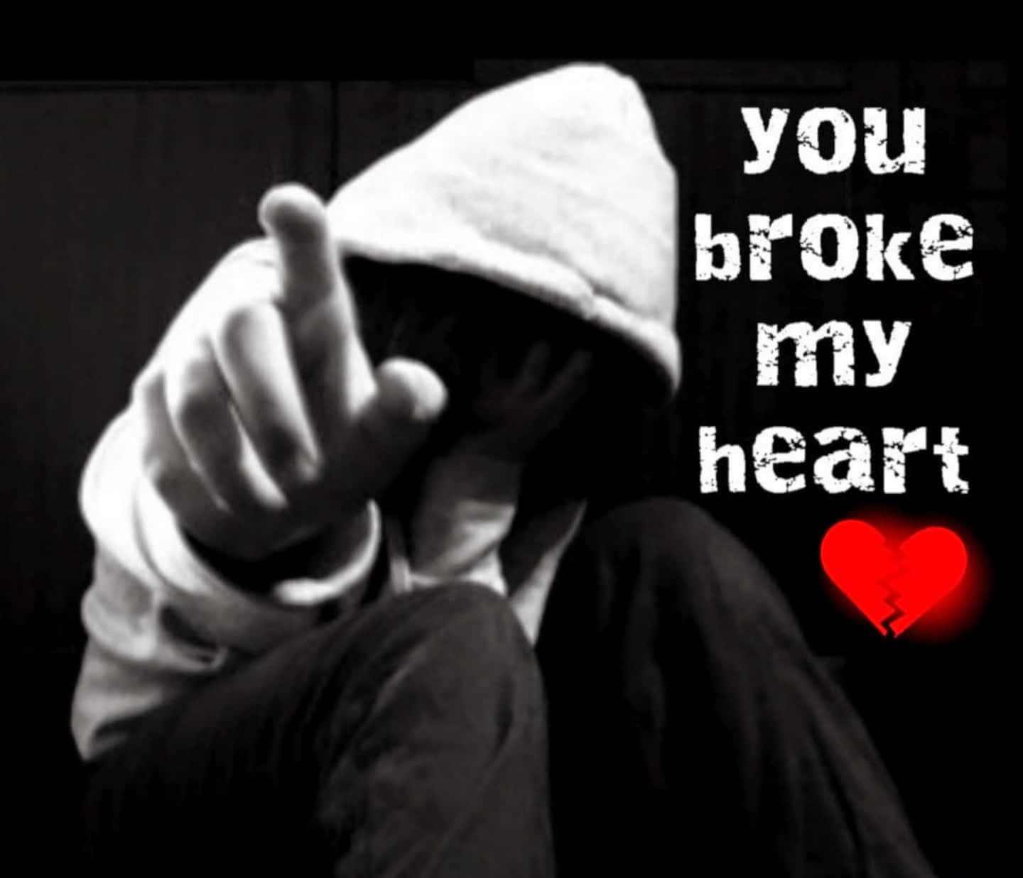Broken Heart Sad 桌布 壁紙 — 一個穿連帽衫的人指責地指著，旁邊的文字宣稱「你傷了我的心」，還有一個發光的紅色破碎心形。