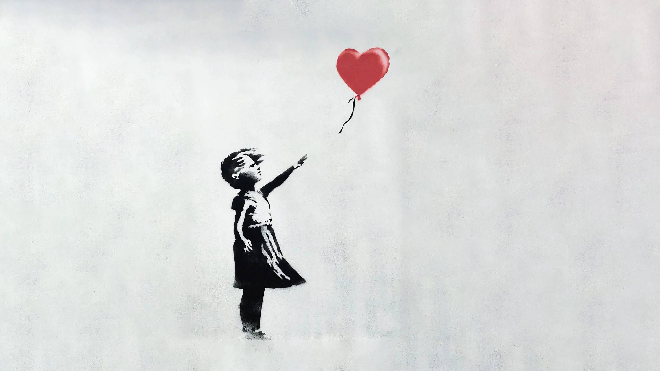 Banksy 桌布 壁紙 — 一個穿黑色衣服的孩子向上伸手，朝向一個漂浮的紅色心形氣球，背景是柔和的灰色。