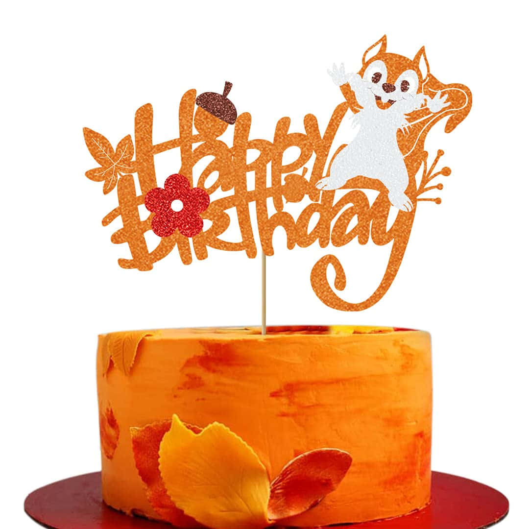 秋季 桌布 壁紙 — 一個節慶橙色蛋糕，上面有一個閃亮的「Happy Birthday」裝飾，包括一隻揮手的松鼠、秋葉和一個橡果。