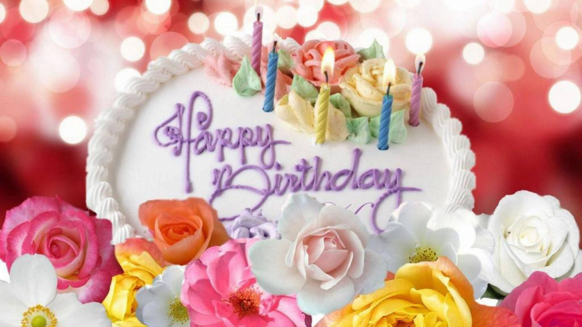 Happy Birthday Flower 桌布 壁紙 — 一個節慶生日蛋糕，飾以彩色玫瑰和點燃的蠟燭，背景是閃爍的紅色散景。